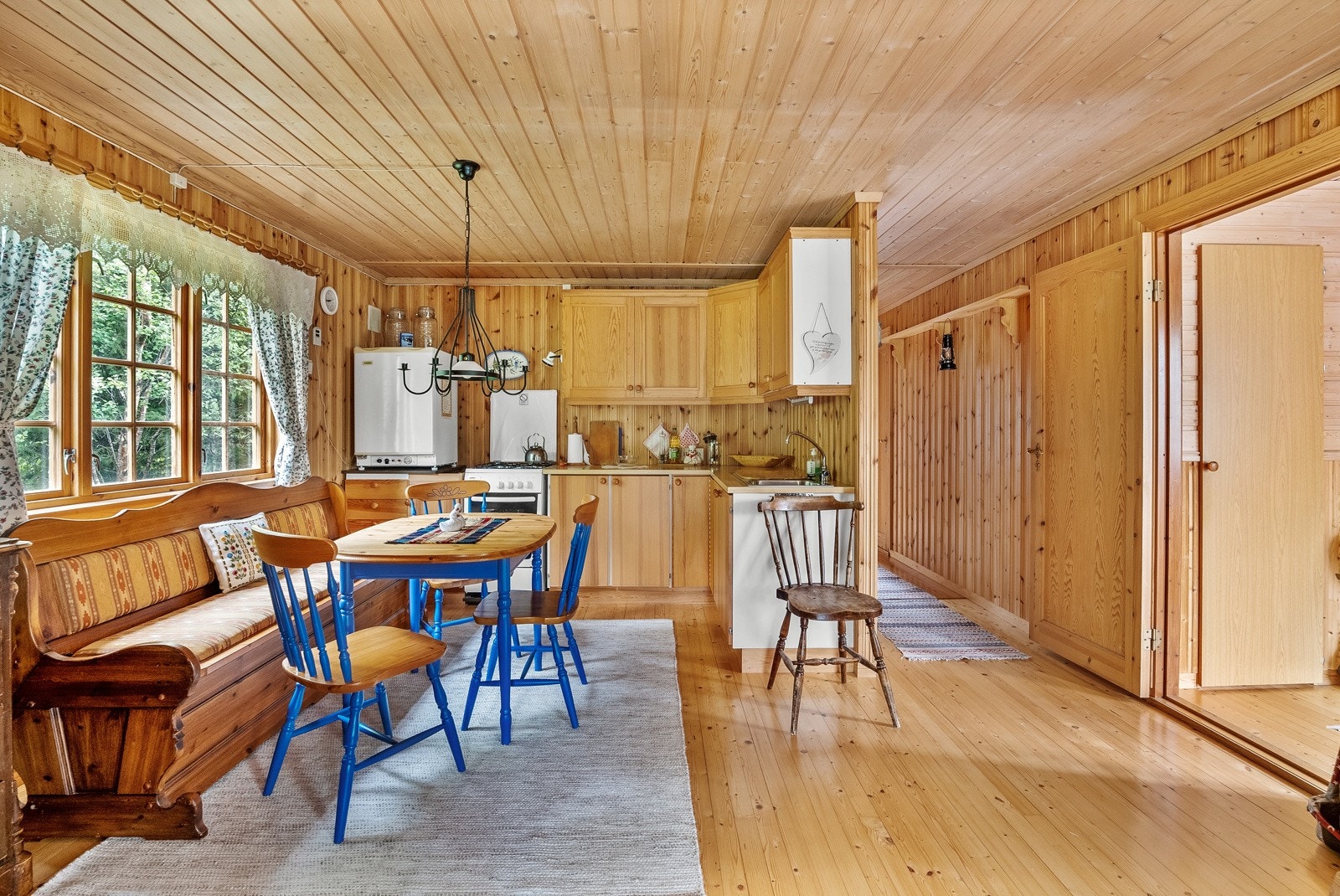 Kjøkken nyter godt av lun varme fra peisovn mellom stue og kjøkken Galleribilde