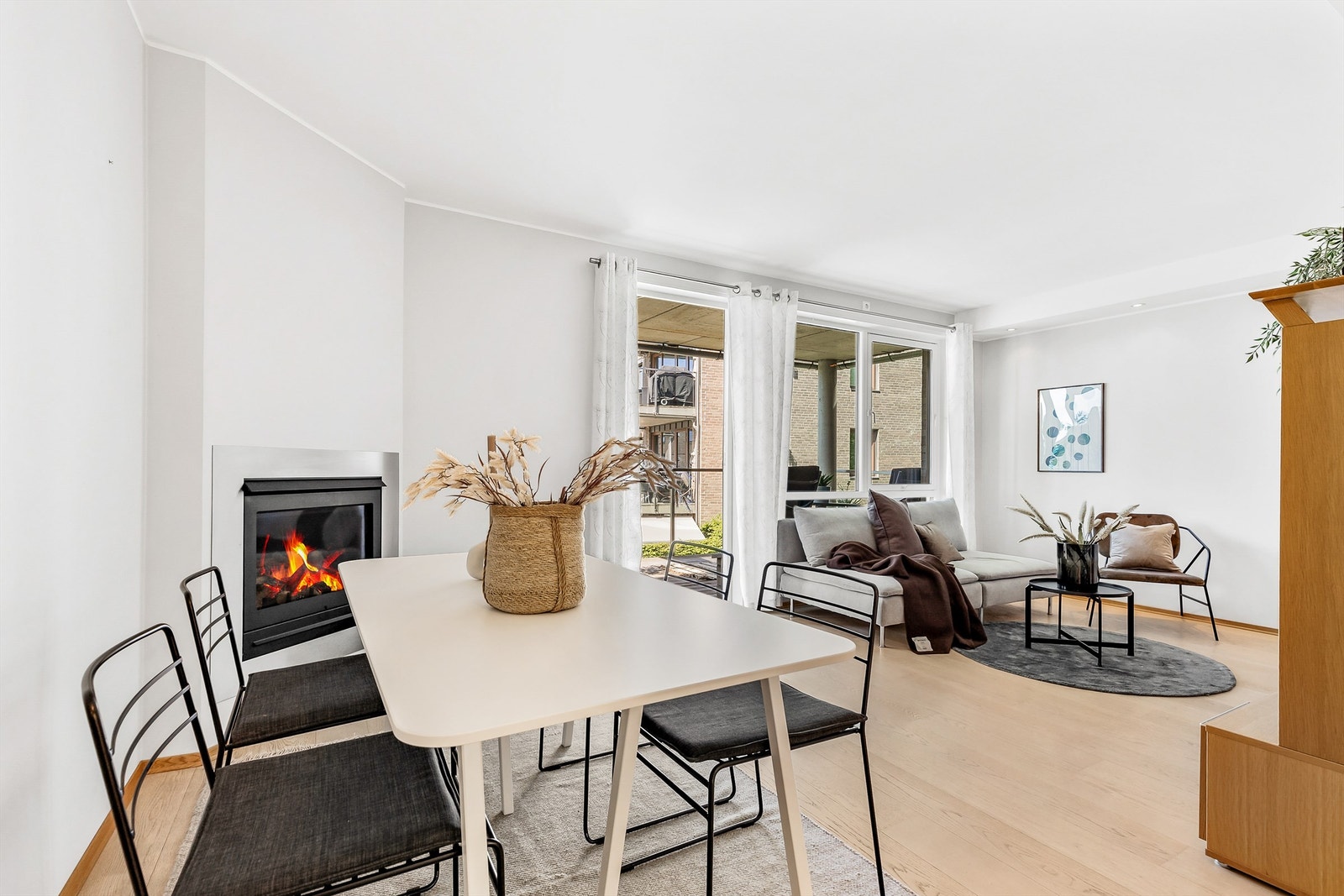 Det er åpen løsning mellom stue, spisestue og kjøkken, og i hjørnet av rommet er det en stilig gasspeis. Galleribilde