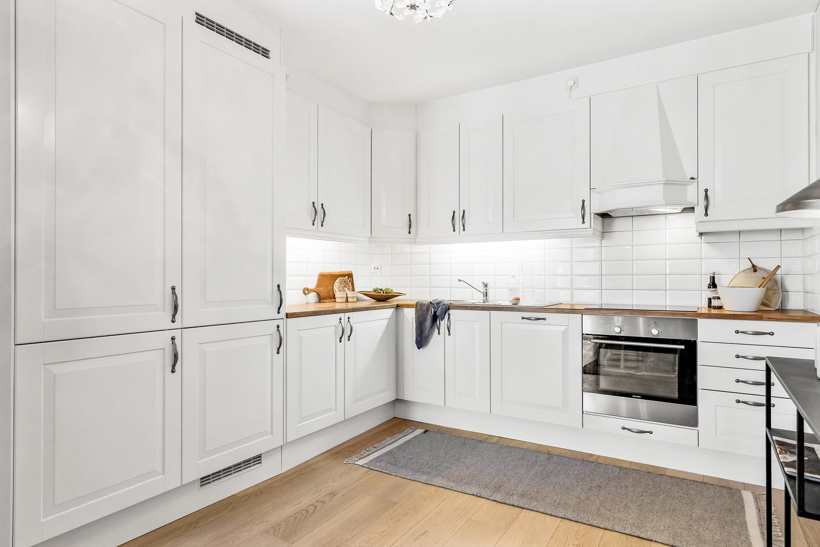 Varmtvannsbereder på ca. 120 liter fra byggeår er plassert i hjørnet under benkeplate. Galleribilde