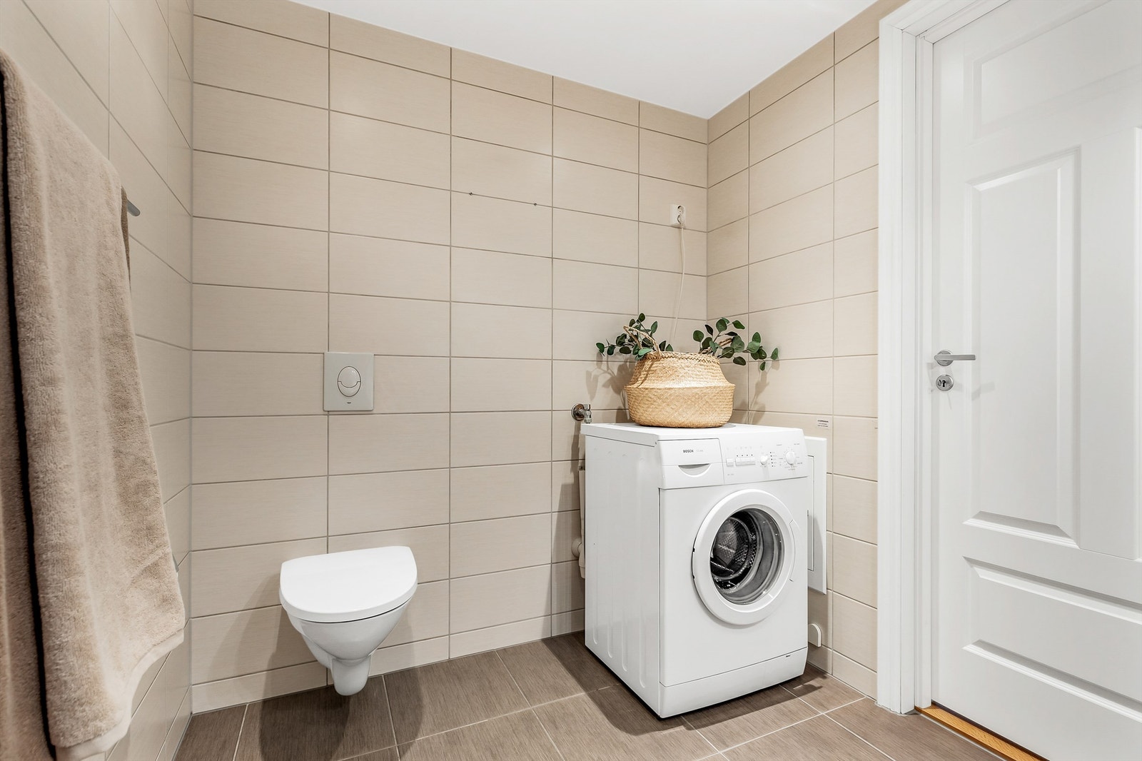 Vegghengt toalett. Det er opplegg for vaskemaskin. Galleribilde