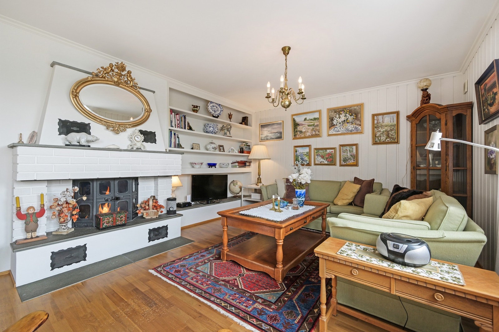 Romslig stue i lyse farger og med peis ovn. Galleribilde