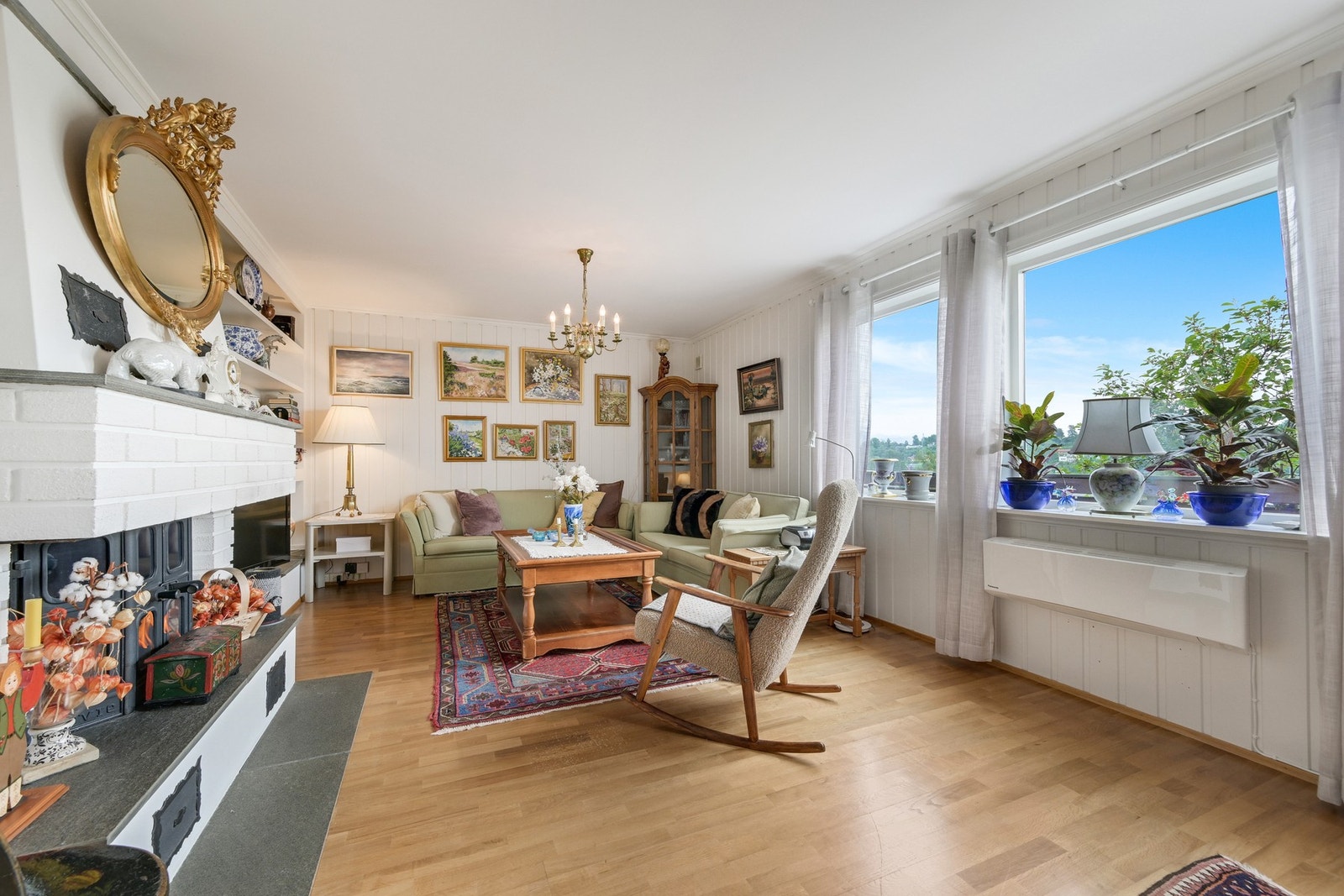 Romslig stue i lyse farger og med peis ovn. Galleribilde