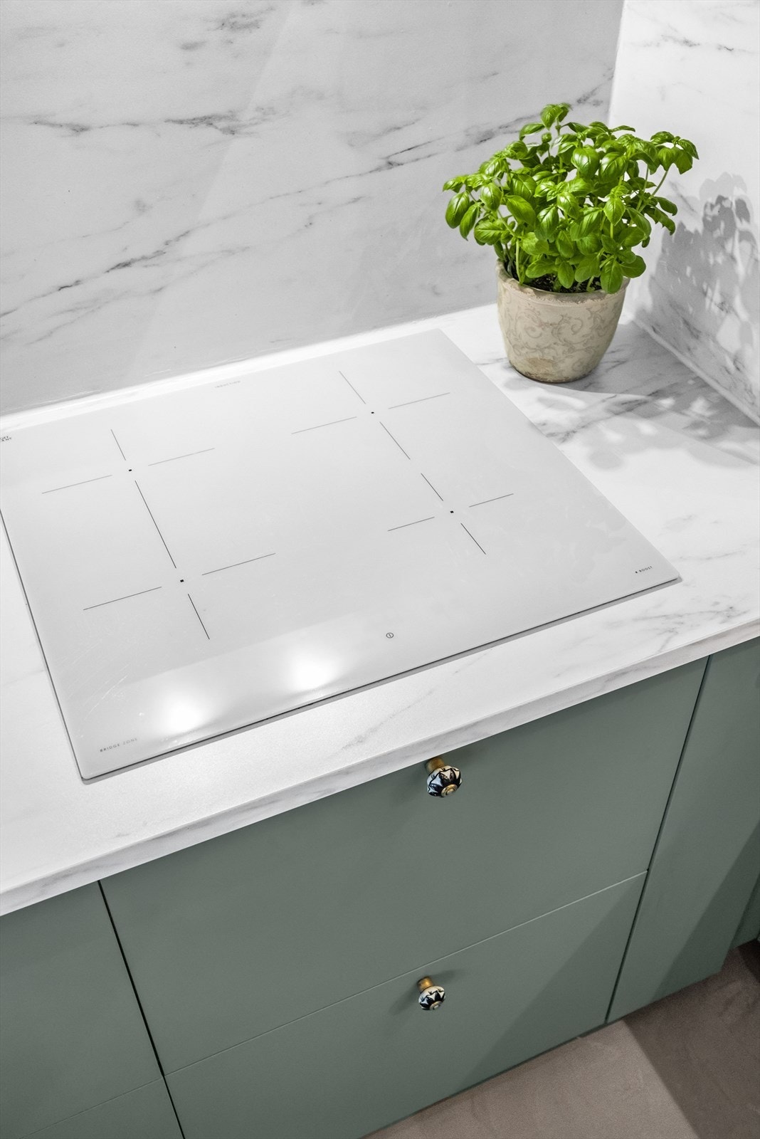 Kjøkkeninnredning med glatte fronter og foliert benkeplate. Kjøkkenet er utstyrt med platetopp, kum med ettgreps blandebatteri, ventilator, kjøl/fryseskap, ovn og oppvaskmaskin. Galleribilde