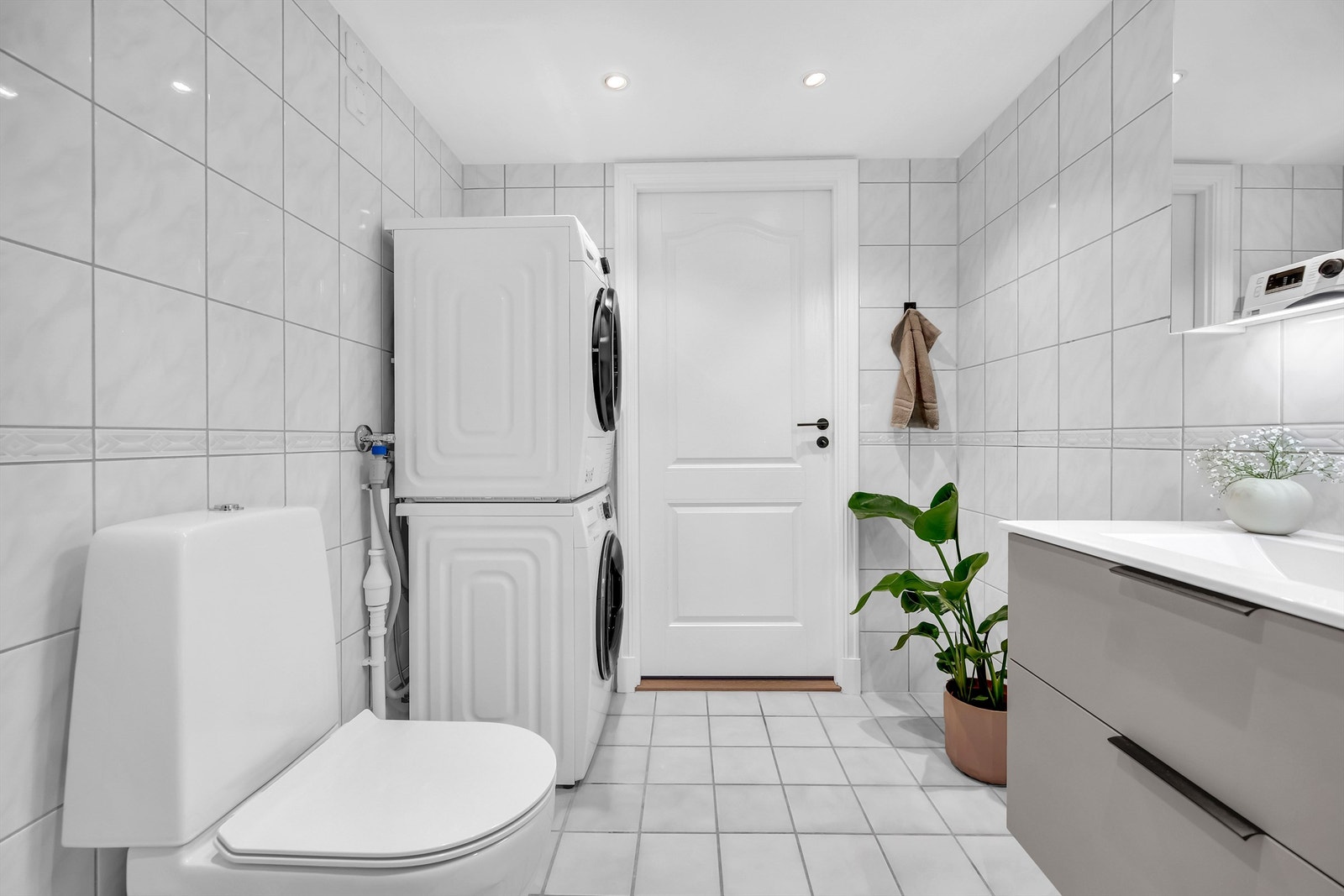 Badet er fliselagt med gulvvarme med opplegg for vaskemaskin og tørketrommel Galleribilde