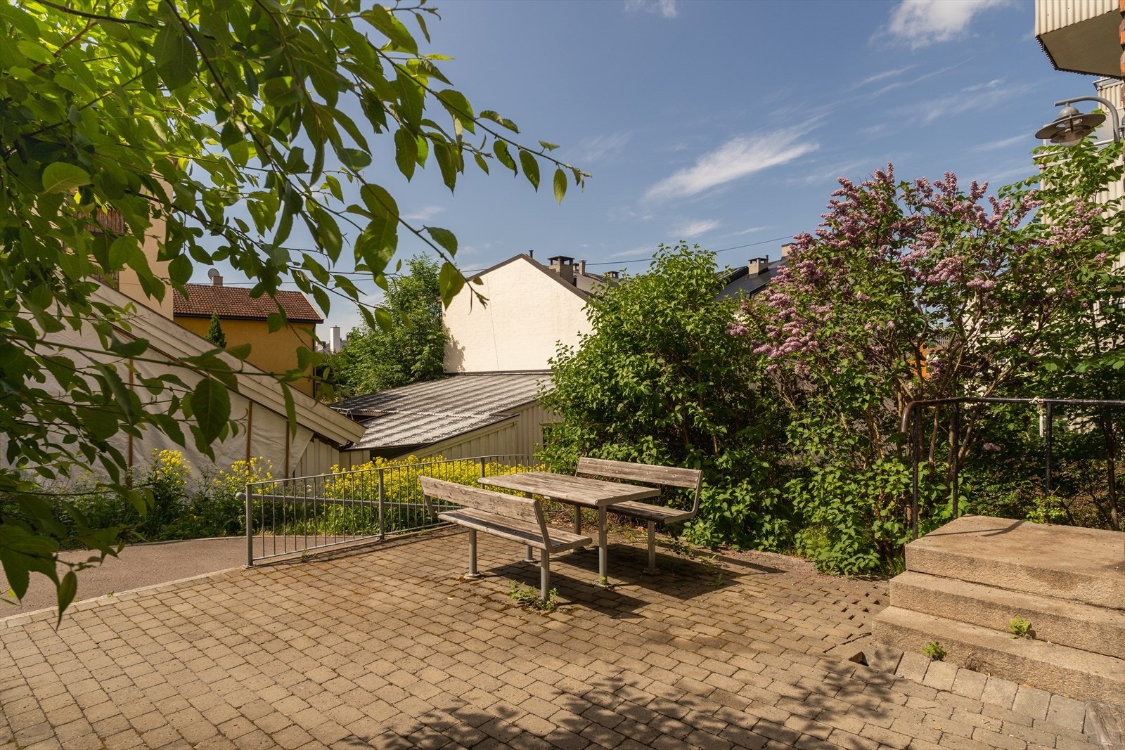 Fellesarealer med sykkelparkering, sittebenker, gressplen, beplantning og interne stikkveier. Galleribilde