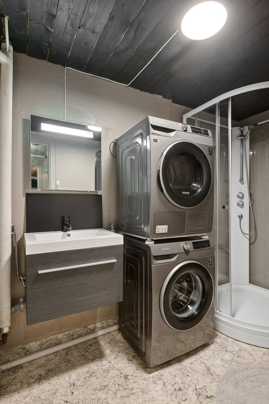 Malte plater og malt betong. Våtromsbelegg og varme i gulv. Rommet har baderomsinnredning, dusjkabinett og opplegg for vaskemaskin. Galleribilde