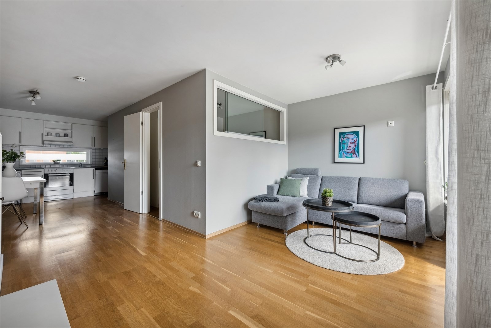 Leiligheten byr på en flott stue som gir en følelse av enkel og stilren innredning. Den åpne planløsningen mellom stue og kjøkken skaper en innbydende atmosfære, perfekt for sosiale samlinger og dagligliv. Galleribilde