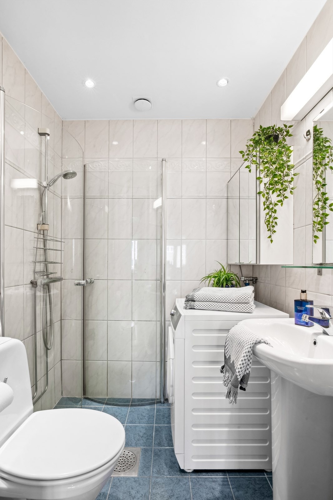 Badet har fliser på gulv og vegger, standard innredning, gulvvarme og dusjhjørne. Galleribilde