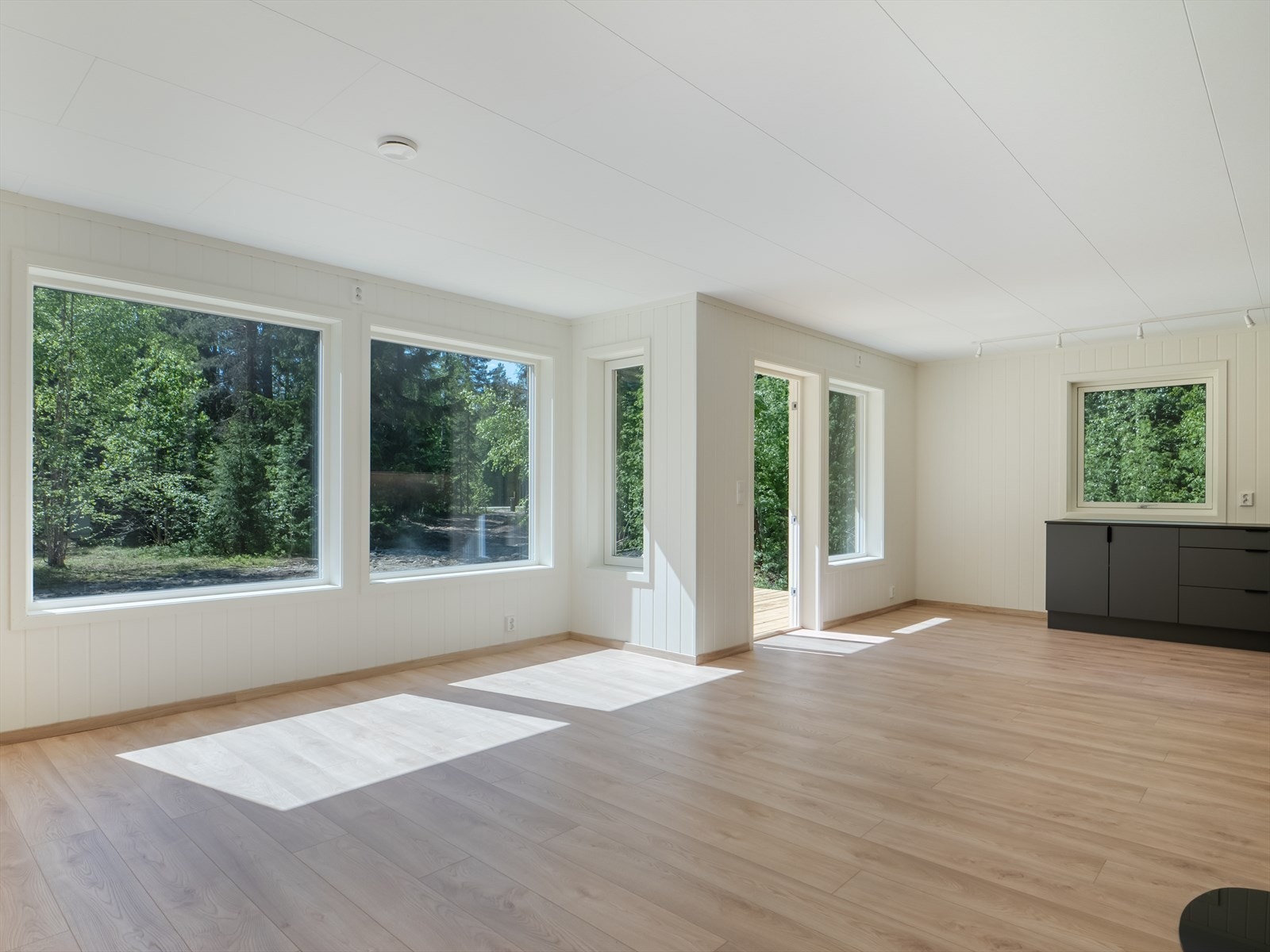 Lys, romslig stue med store vinduer som gir mye naturlig lys. Galleribilde