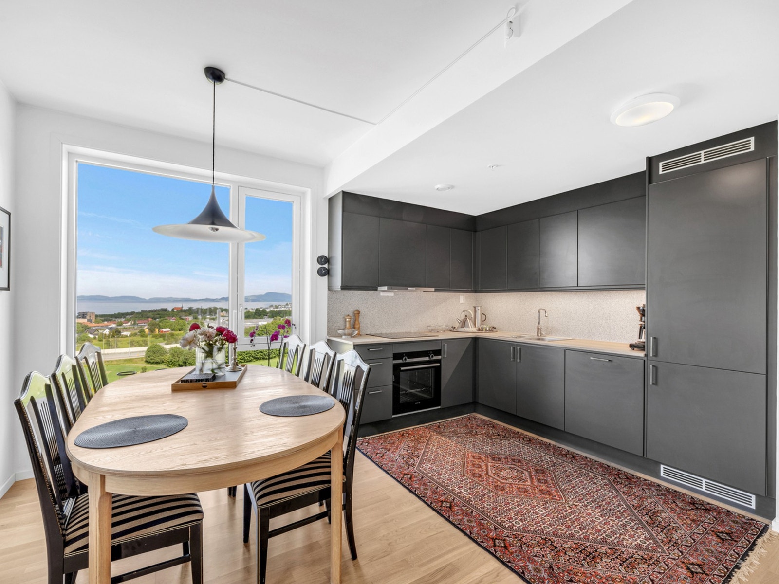 Leiligheten ble ferdigstilt så sent som i oktober 2021. God plass til stort spisebord i overgang mellom stue og kjøkken. Galleribilde