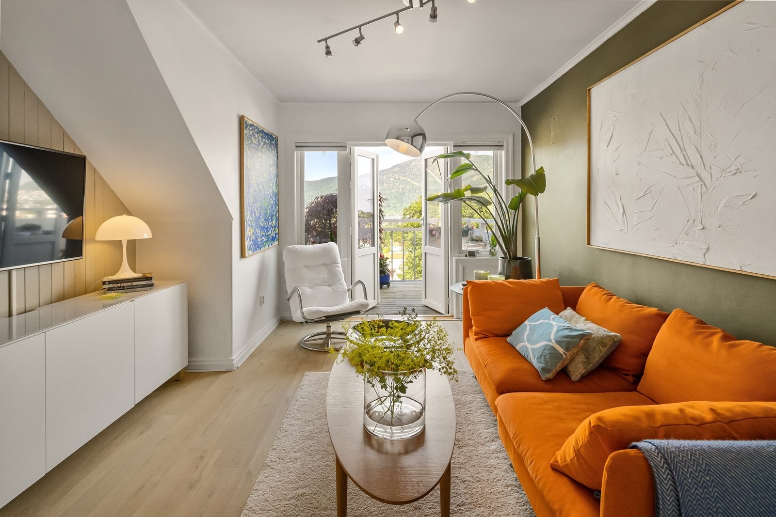 De vestvendte vinduene sørger for rikelig med innslipp av dagslys og gjør at stuen føles lys og luftig. Galleribilde
