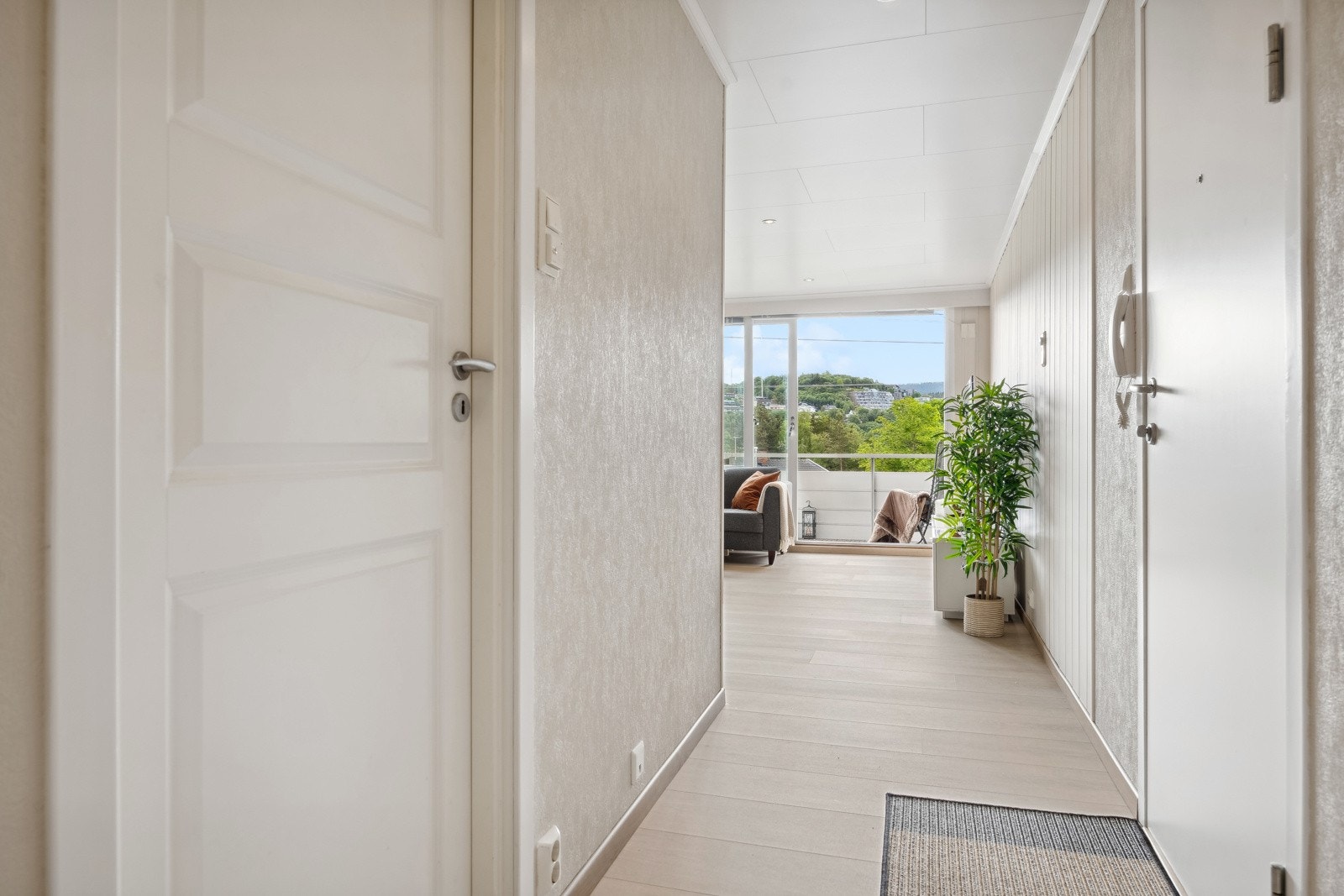 Man kommer inn i leiligheten via en lys og romslig gang med god plass til vegghengt klesoppbevaring og garderobeskap. Galleribilde