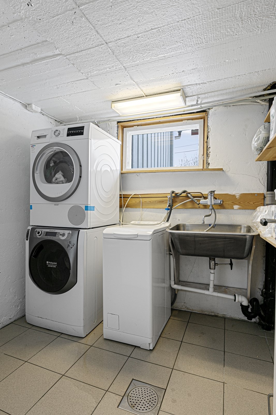 Eldre vaskerom med utslagsvask og opplegg for vaskemaskin og tørketrommel. Rommet har behov for modernisering på sikt. Galleribilde