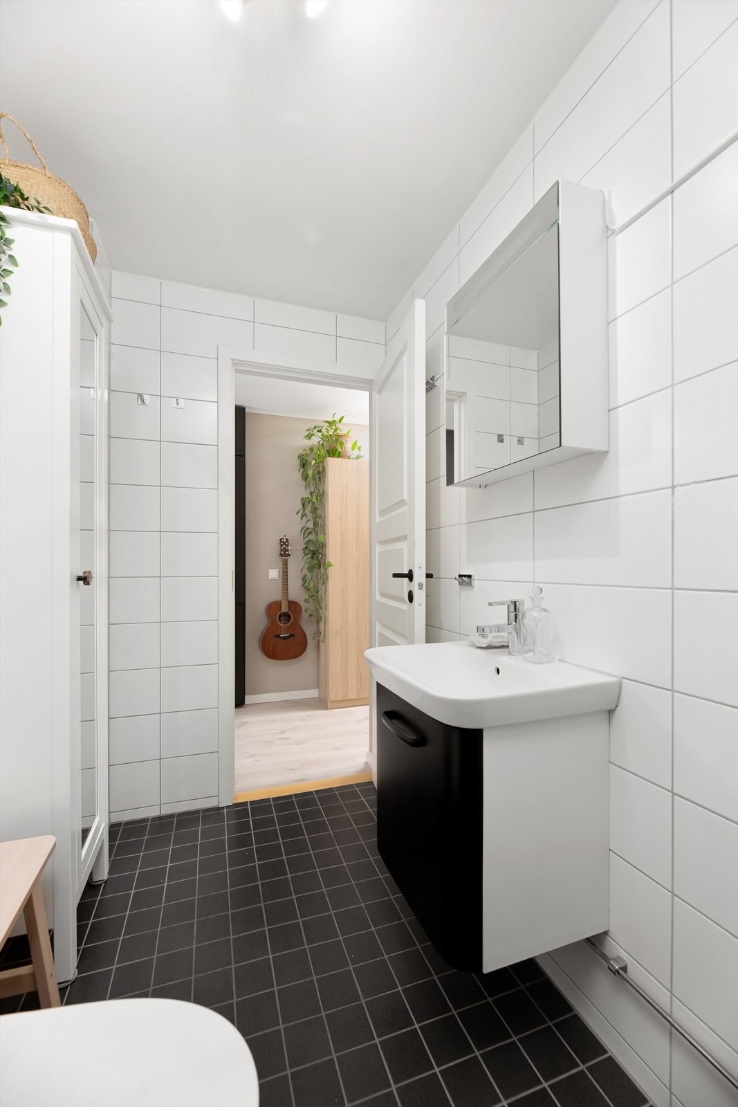 Badet har servant med underskap, speilskap, wc og dusj med skyvedører i herdet glass. Galleribilde