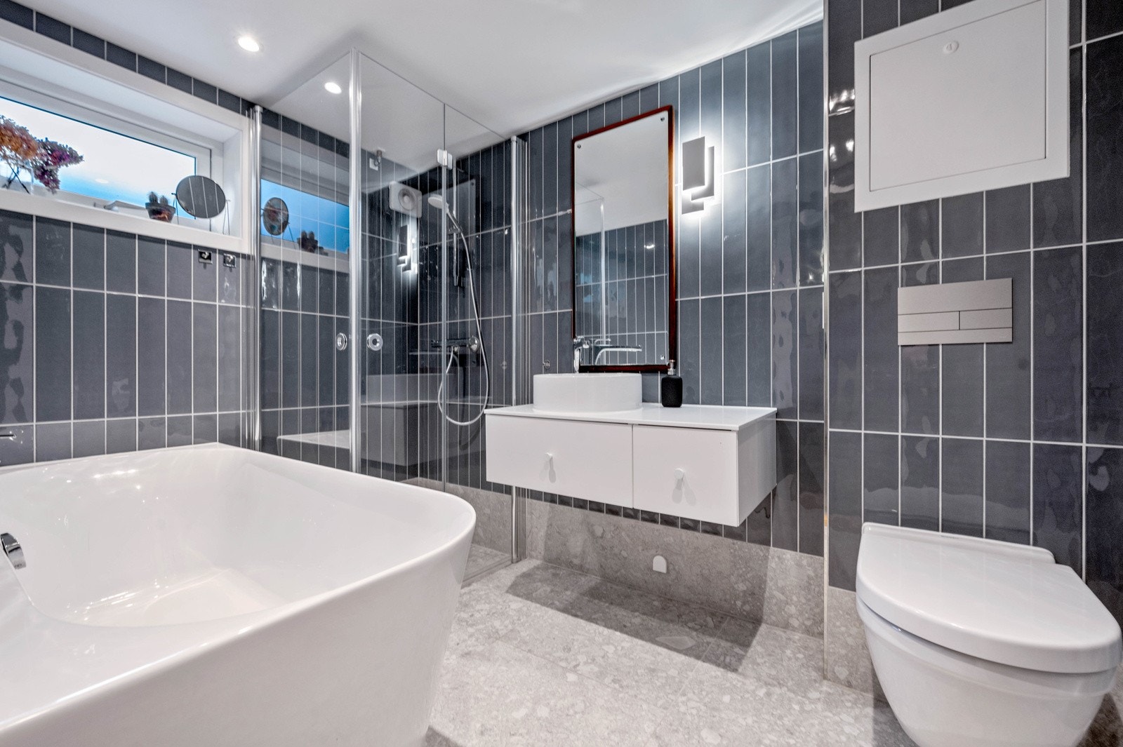 Lekkert oppusset bad (2021) med eksklusive fliser på gulv og vegger, varmekabler. Dusjhjørne med 2 stk svingbare glassdører og stort badekar. Avtrekk. Galleribilde
