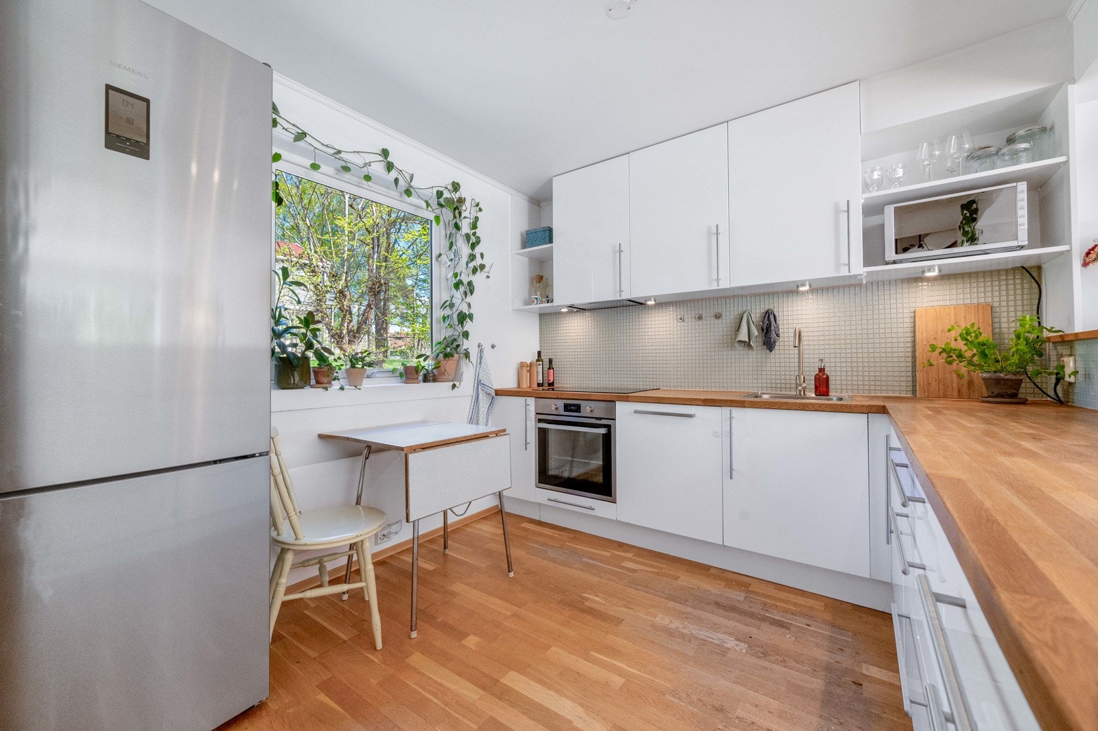 Et hyggelig kjøkken med spiseplass ved vinduet. Galleribilde