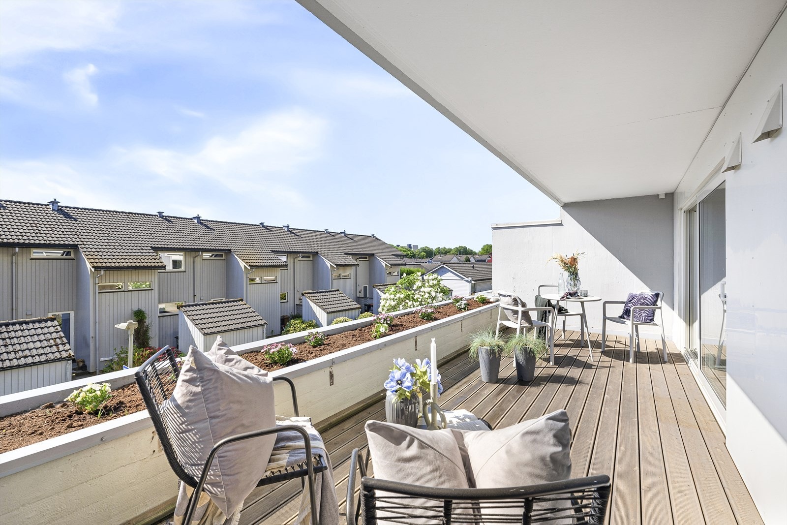 Balkong med plass til utemøbler og grill med fin beplanting i bed. Galleribilde