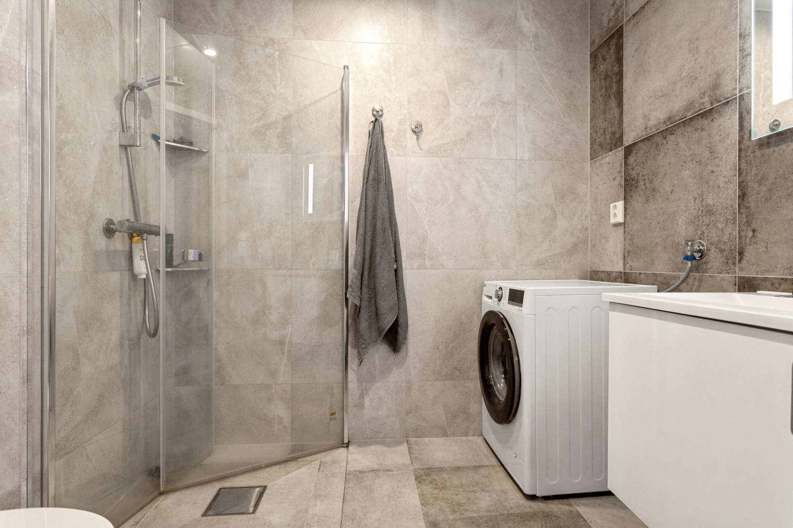 Flislagt bad med opplegg for vaskemaskin. Galleribilde