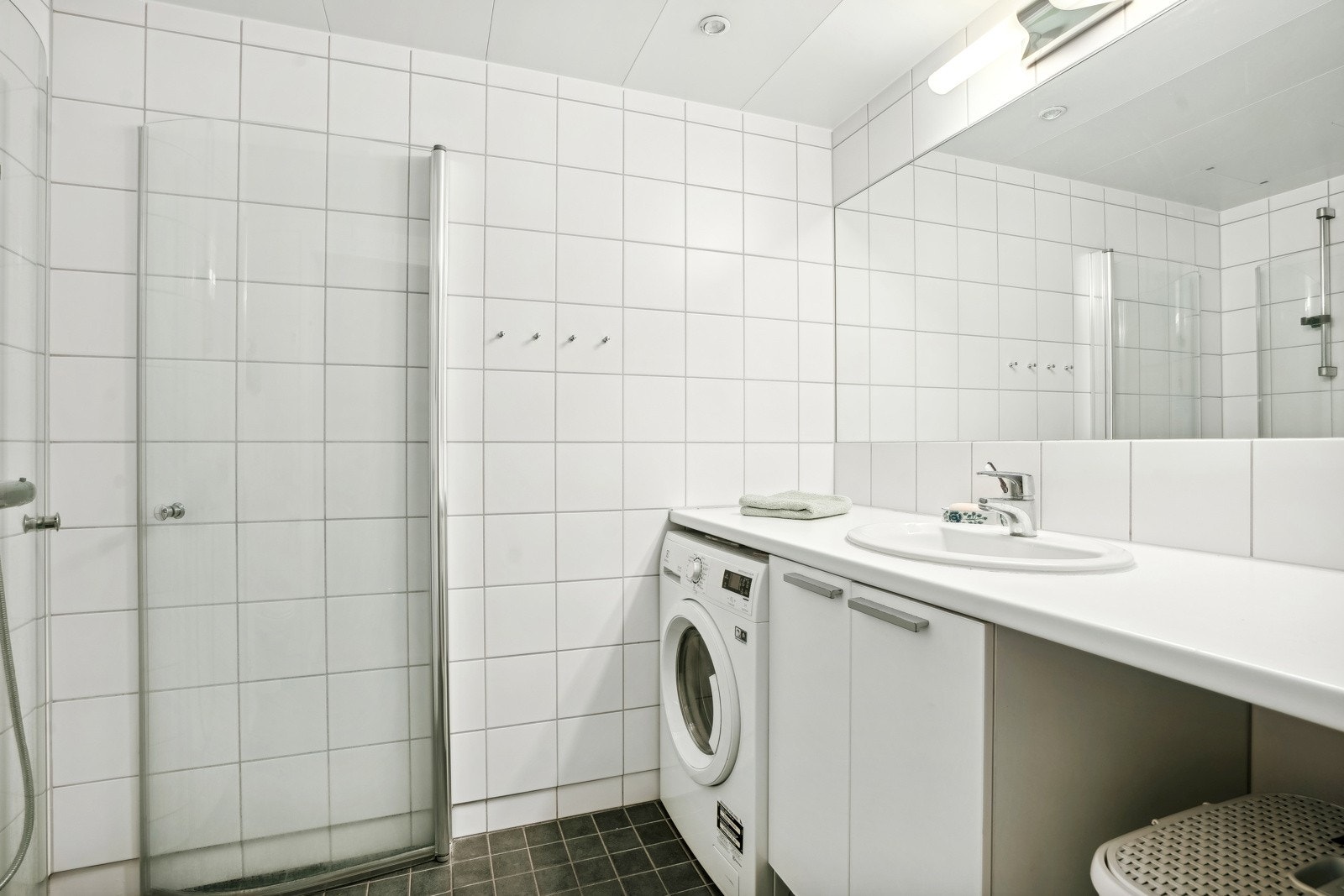 Romslig flislagt bad med downlights og gulvvarme Galleribilde