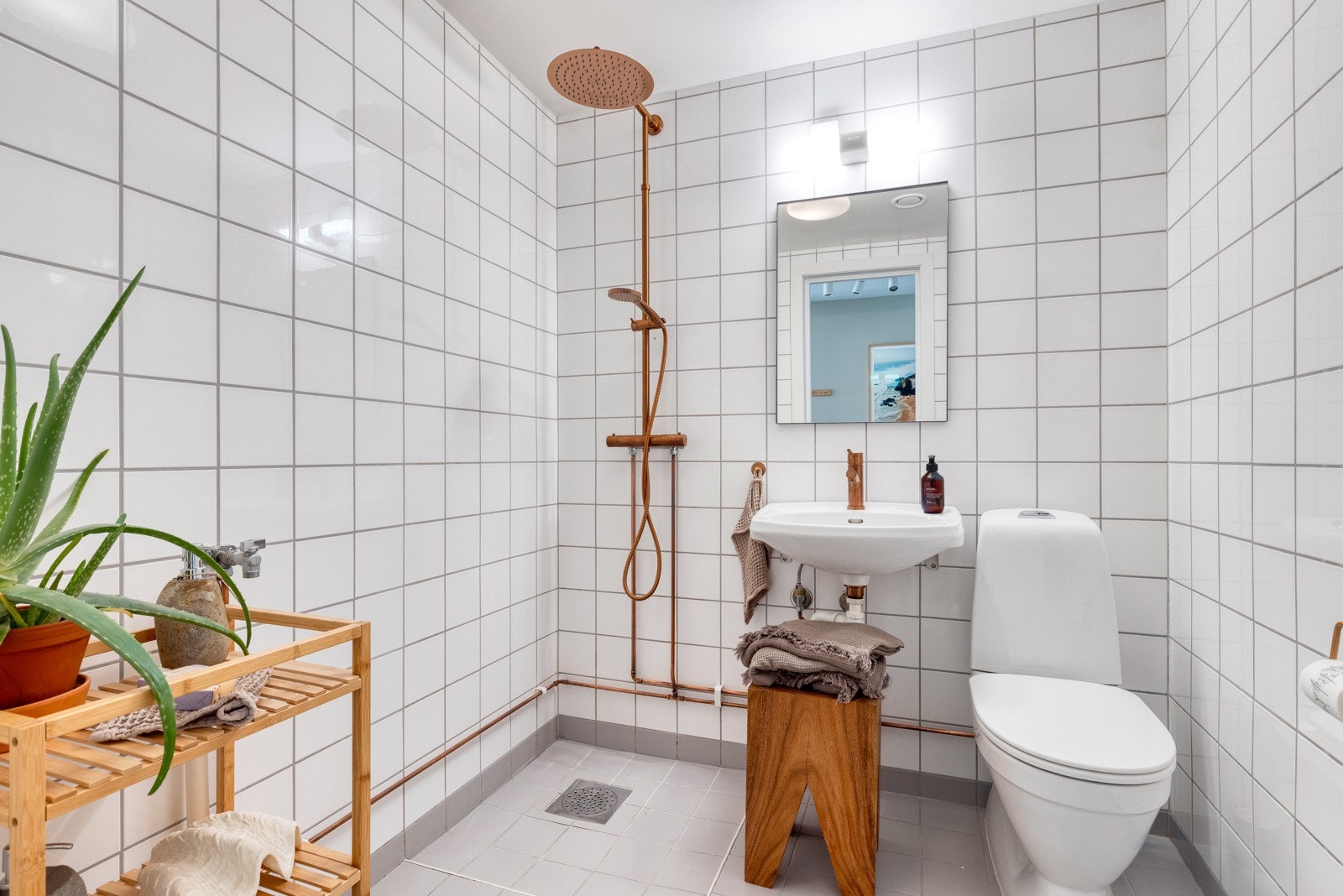 Badet er fra 2004, og er innredet med servant, speil med lys over, dusj og gulvstående toalett. Galleribilde