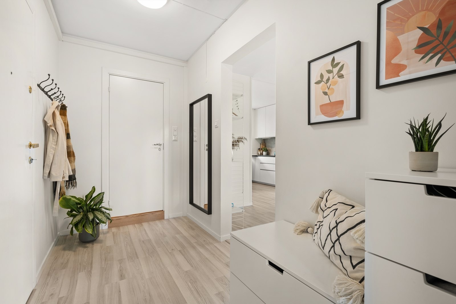 Romslig entrè med plass til oppbevaring av sko og yttertøy. Her bor du i rolig oppgang med kun seks leiligheter Galleribilde