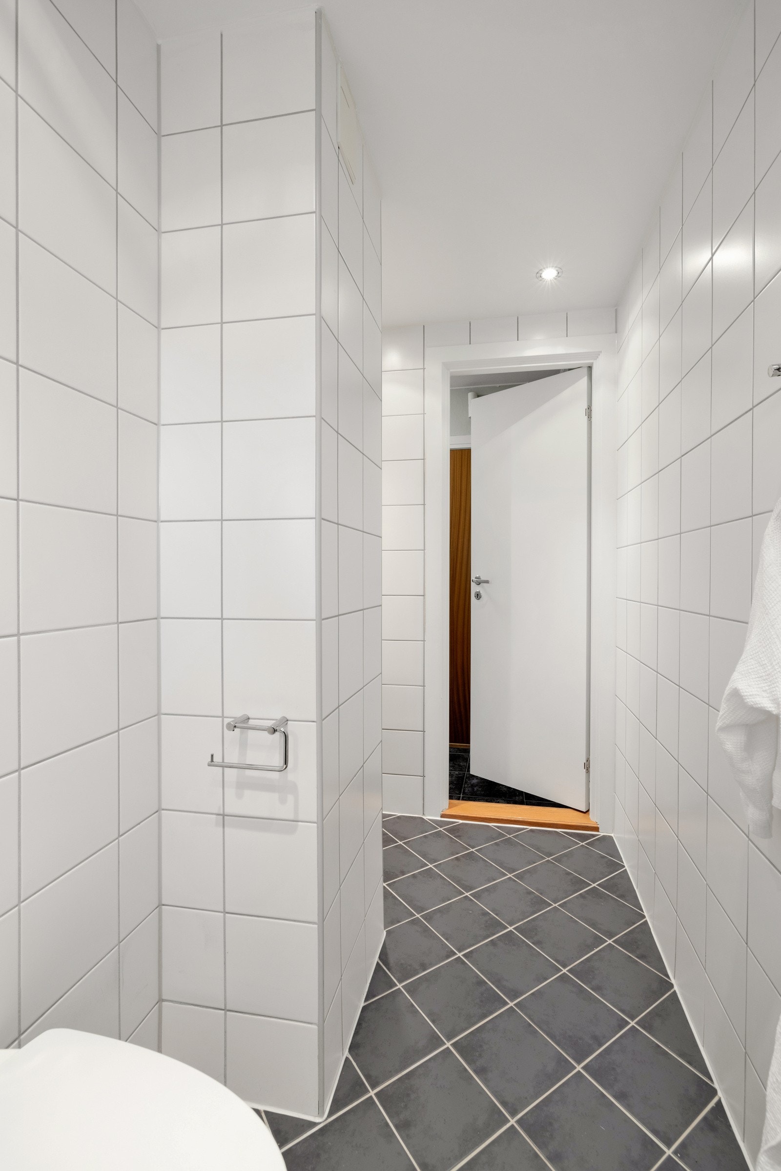 Videre har badet vegghengt toalett og et dusjhjørne med innfellbare glassdører Galleribilde