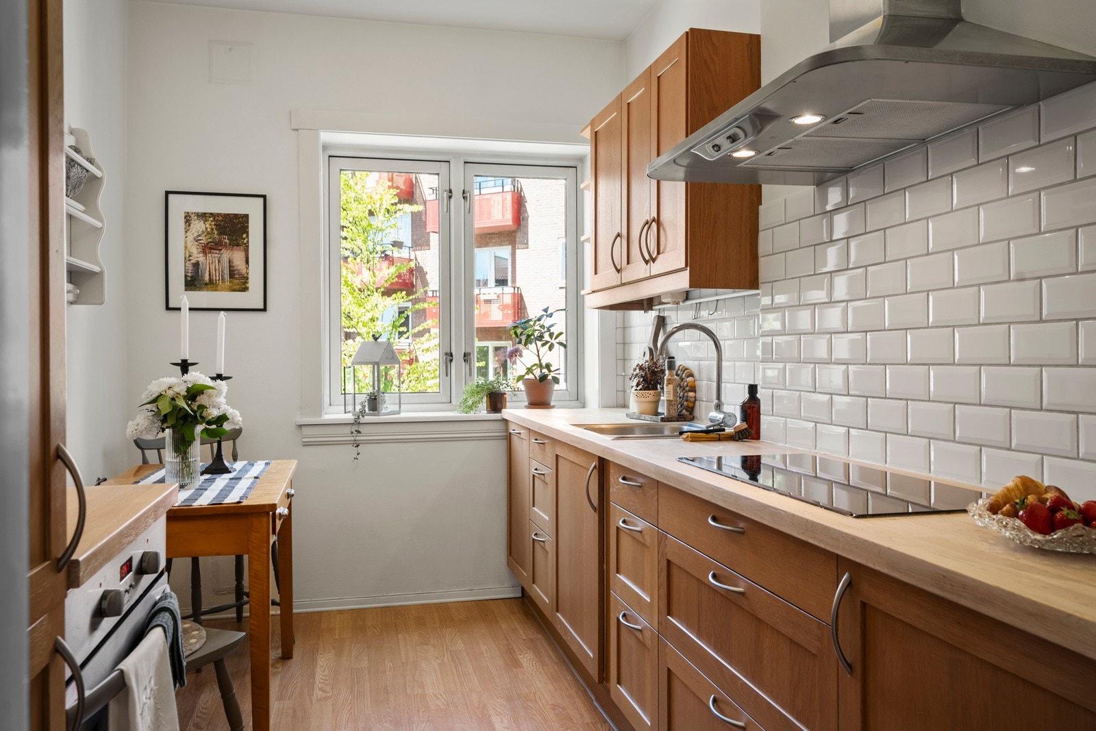 Kjøkkeninnredning med bredprofilerte fronter av lys trefinér. Galleribilde