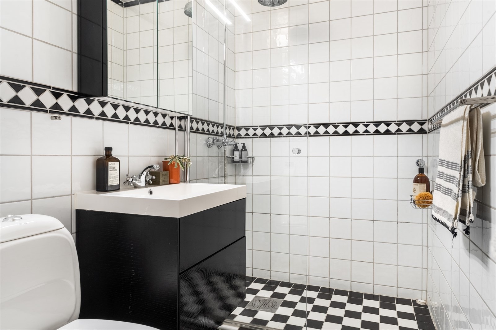 Badet i 3. etasje med flis på gulv og flis på vegger. Malt overflate i himling. Gulvvarme. Utstyrt med wc, servantskap, dusjhjørne, innfellbare dusjdører, mekanisk avtrekk og opplegg for vaskemaskin. Galleribilde