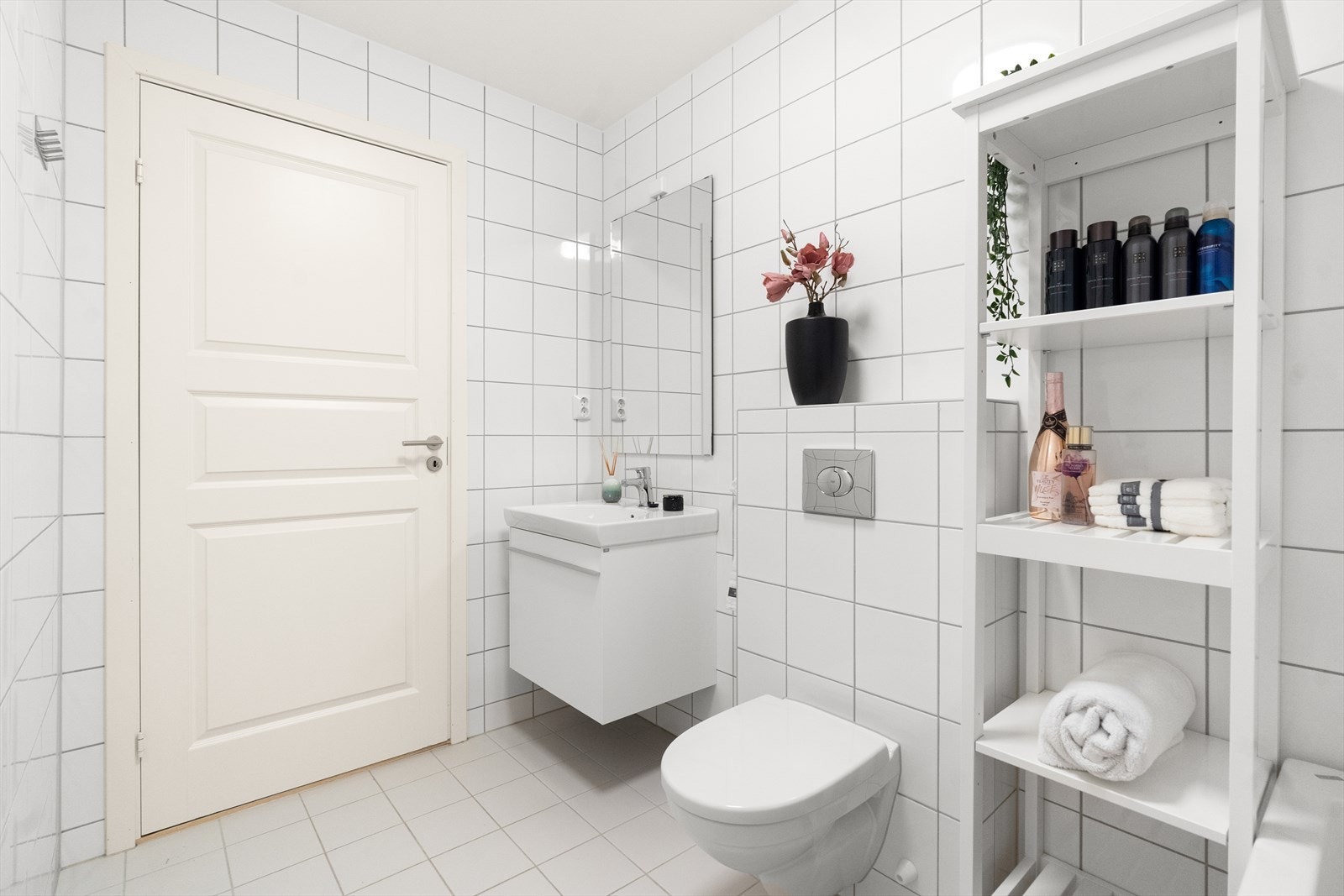Det har glatt baderomsinnredning med heldekkende servant nedfelt i underskap, speil m/lys, veggmontert toalett og badekar m/ dusj. Galleribilde