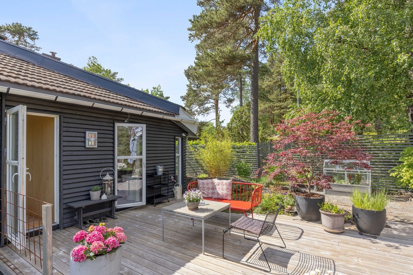 Utgang til terrassen fra både soverom og bad - terrassen er terrengtilpasset slik at du får frem naturtomten med bed, knauser og stauder Galleribilde