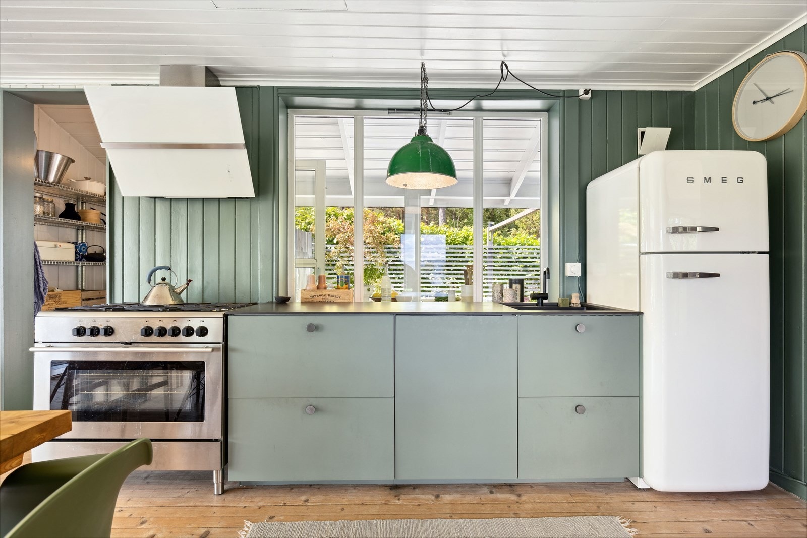 Keramisk benkeplate med underlimt kum fra Kvik og Vola sort kran kjøkkenvask. Smeg, frittstående retrokjøleskap fra 2014. Gasskomfyr 90cm bredde, fire bluss pluss stort wokbluss- Elektrisk stekeovn og vifte Galleribilde