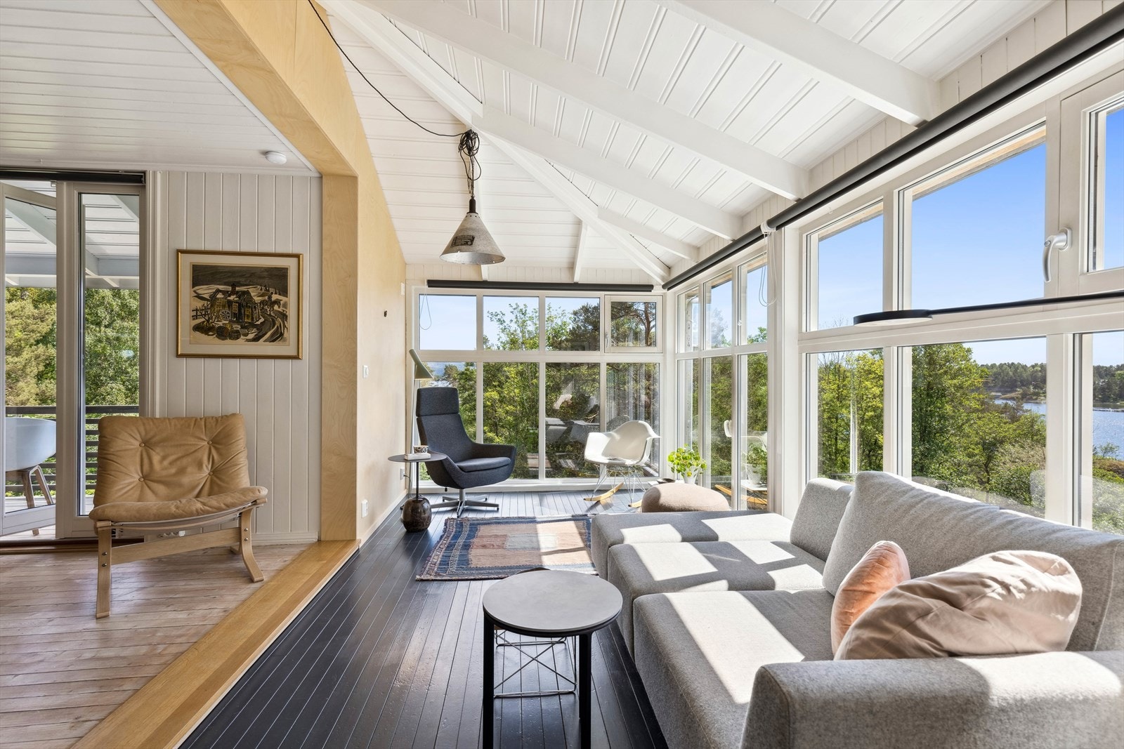 Lys og åpen stue med vinduer fra gulv til tak - her blir overgangen mellom ute og inne visket ut Galleribilde