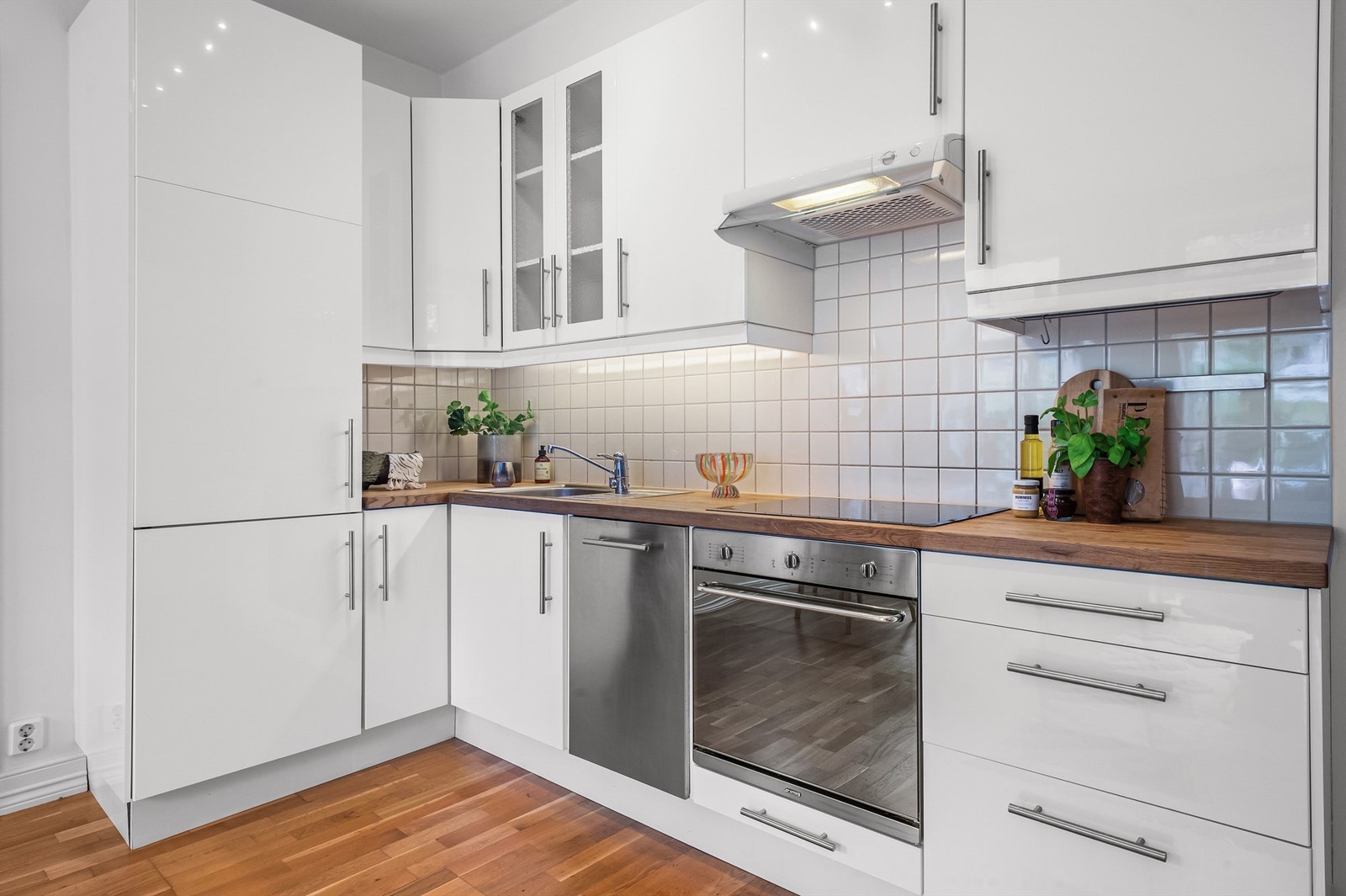 Kjøkken med integrerte hvitevarer, bestående av komfyr, platetopp, oppvaskmaskin og kombiskap kjøl/frys. Galleribilde