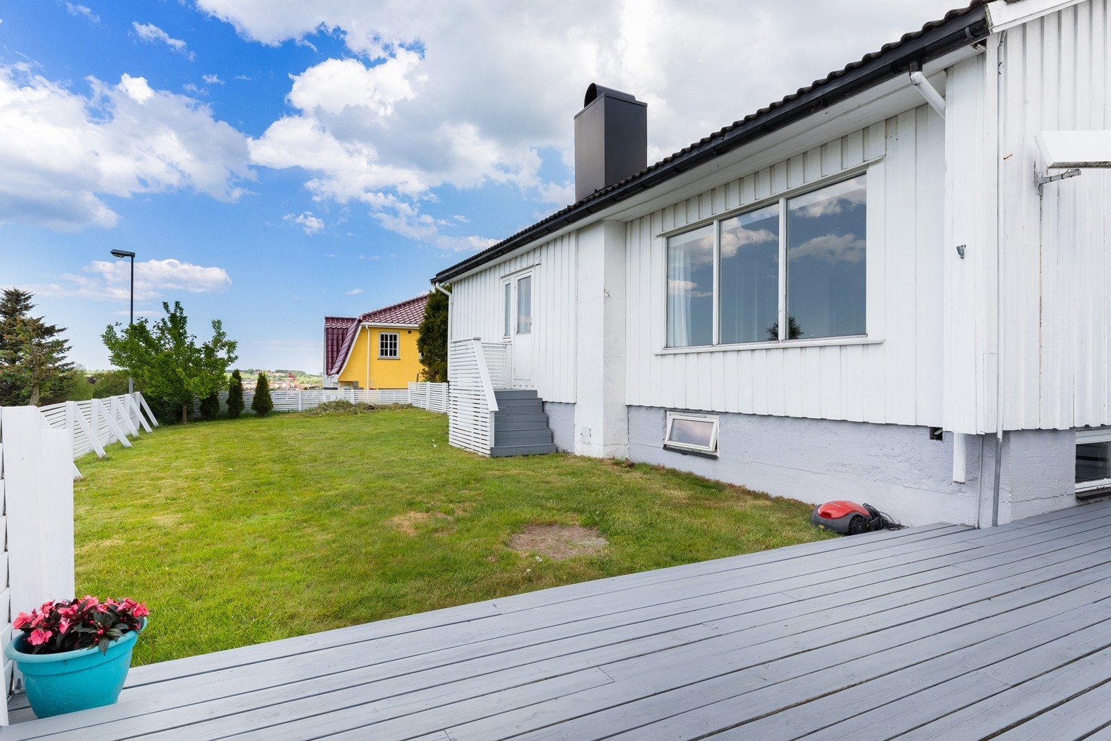 Hagen er innegjerdet med port ved husvegg Galleribilde