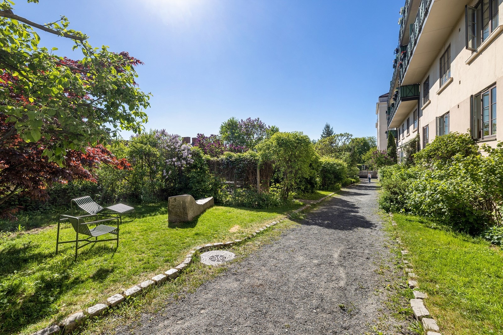 Idyllisk bakhage med sittegrupper, beplanting og koselig internvei. Galleribilde