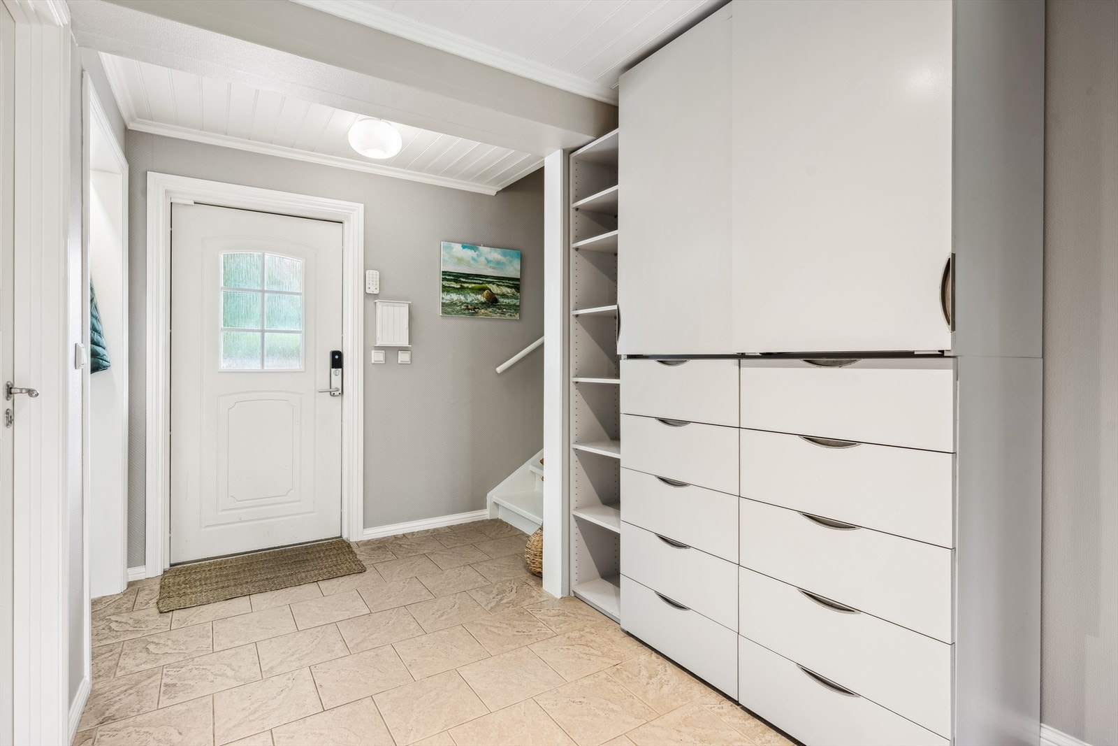 Inngang/hall i første etasje - en innbydende rom med god plass til av- og påkledning. Her er det garderobenisje, en bod og et stort garderobeskap. Galleribilde