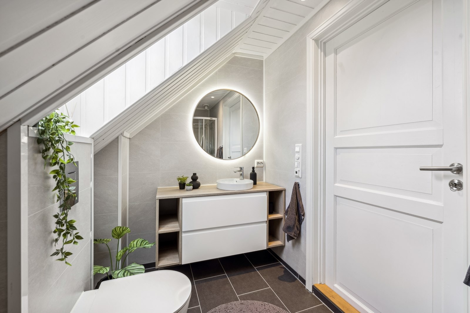 Baderommet har vaskemaskinopplegg samt stilig skuffinnredning med servant og lyssatt speil over. Galleribilde