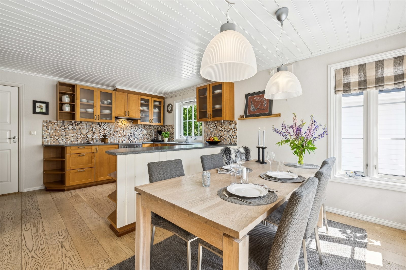 Den ene benkeseksjonen vender mot spiseplassen og har en praktisk funksjon som romdeler og serveringsdisk. Galleribilde