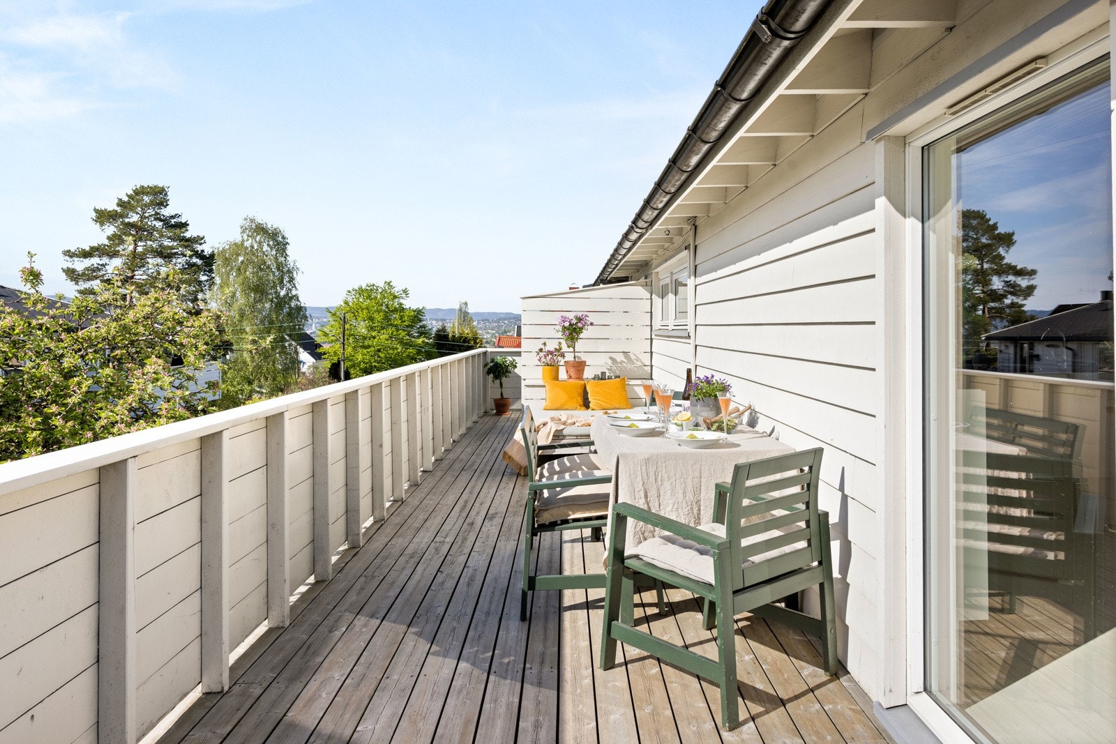 Usjenert veranda i 2. etg med sol fra tidlig morgen til den går ned over hustakene i vest. Galleribilde