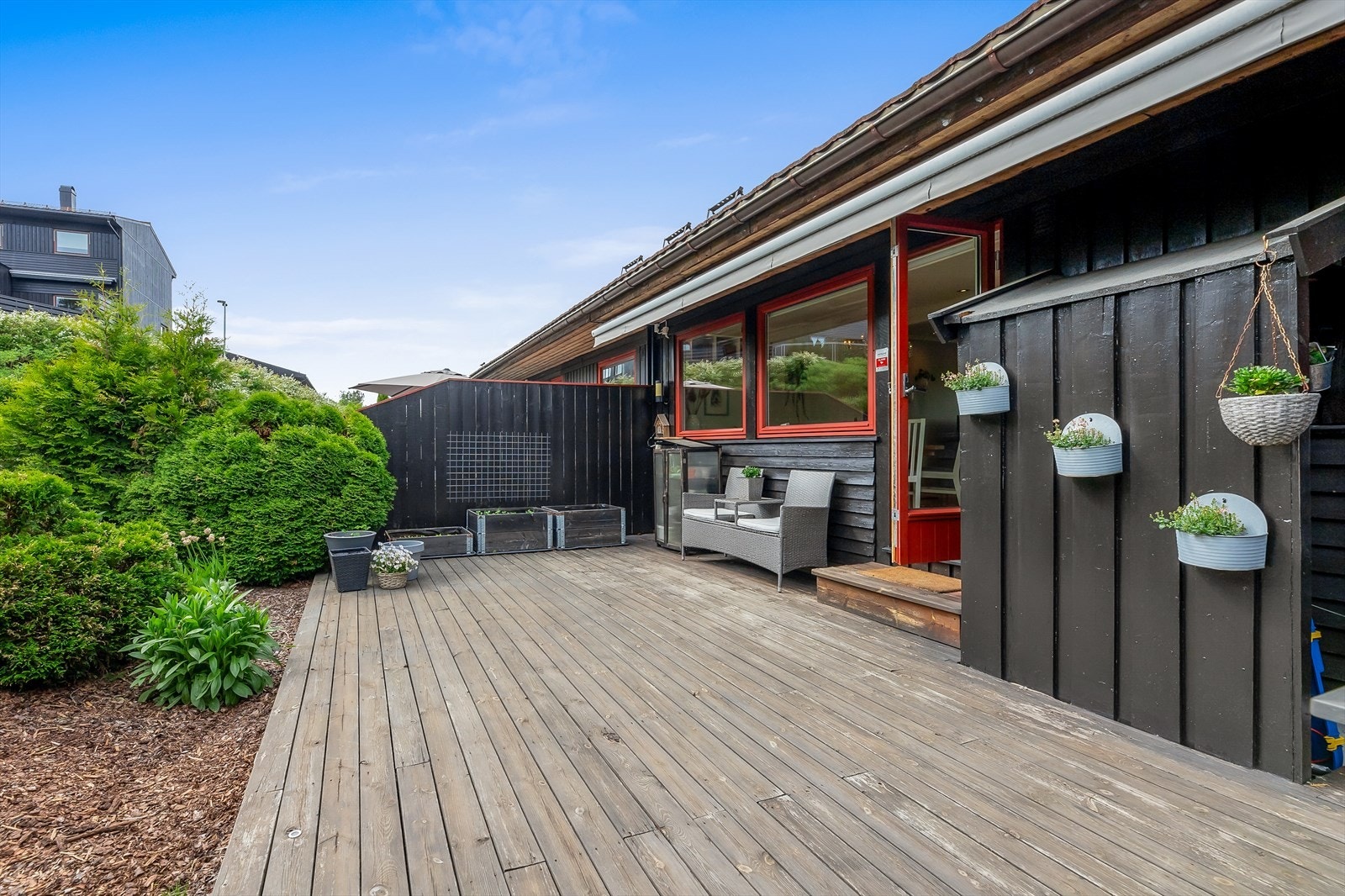 Terrassen rommer spisegruppe, loungeavdeling, grill, solsenger, planter og dekor Galleribilde