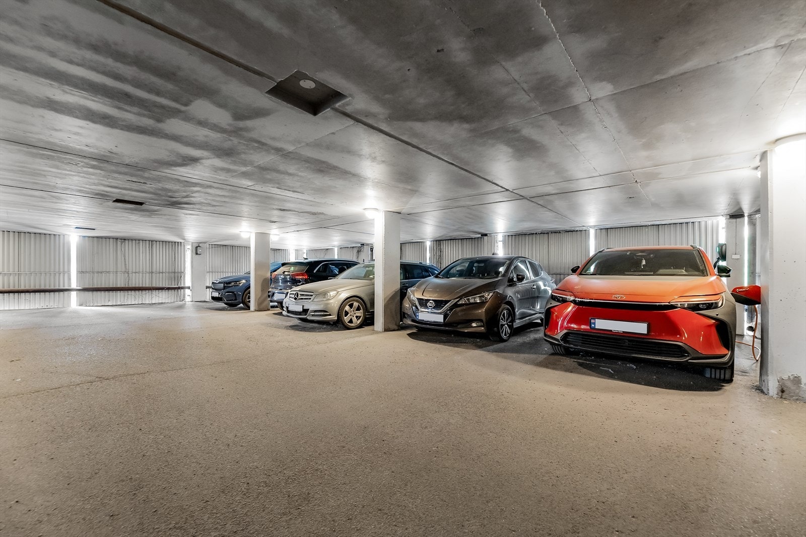 Bilen parkeres trygt på medfølgende plass med elbillader i felles garasjeanlegg Galleribilde