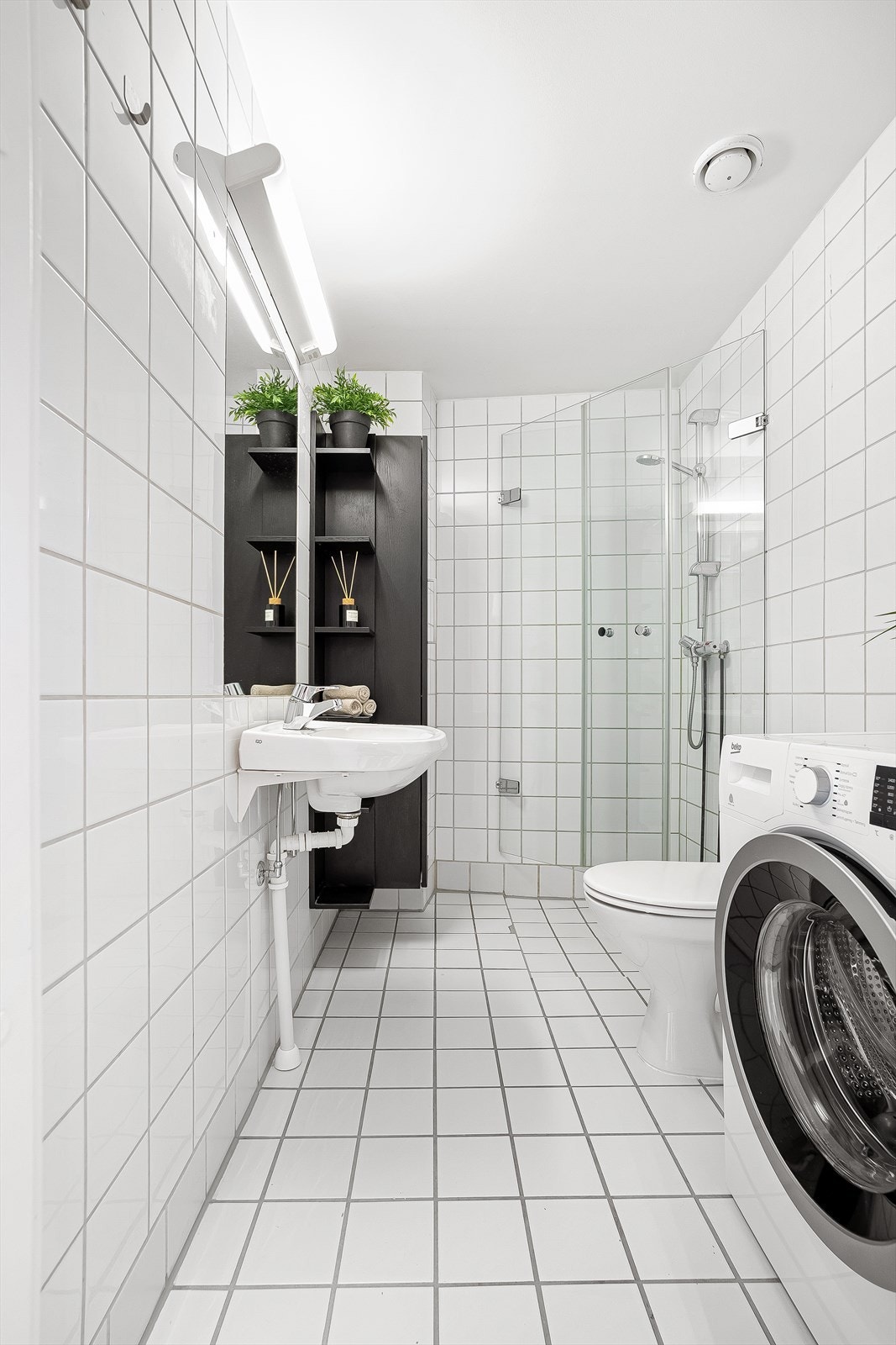 Videre er det dusjhjørne med dører av glass med vegghengt dusjarmatur. Galleribilde