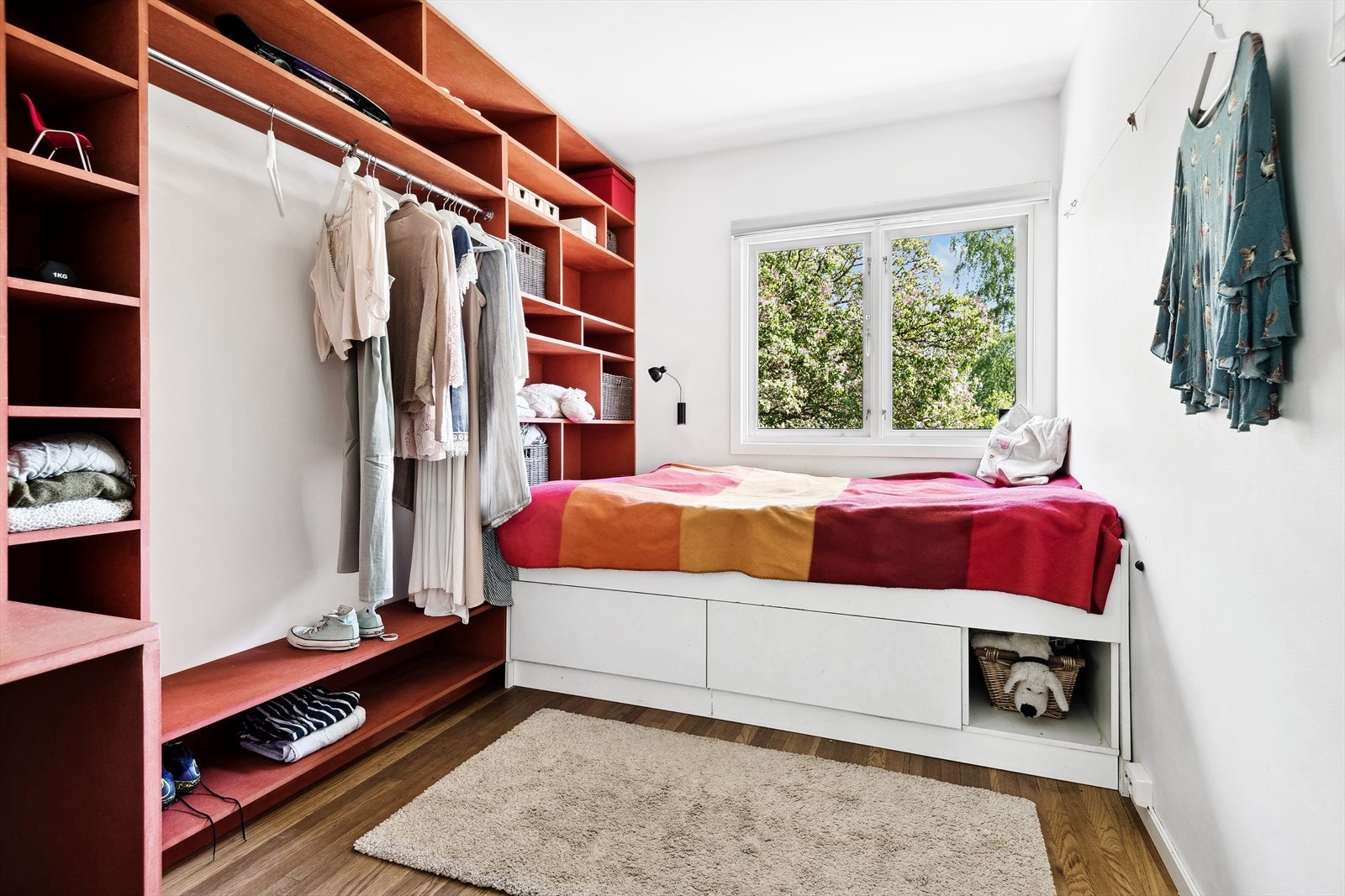 Stilig, plassbygd skrivebordspult med garderobeløsning og dekorative hyller, i rød tråd med boligens øvrig innredning. Galleribilde