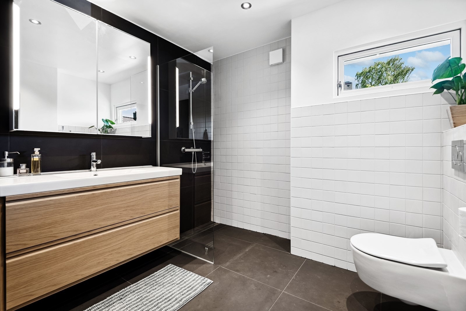 Dagslys fra vindu gir en behagelig og åpen følelse på badet. Varmeklaber i baderomsgulv. Galleribilde