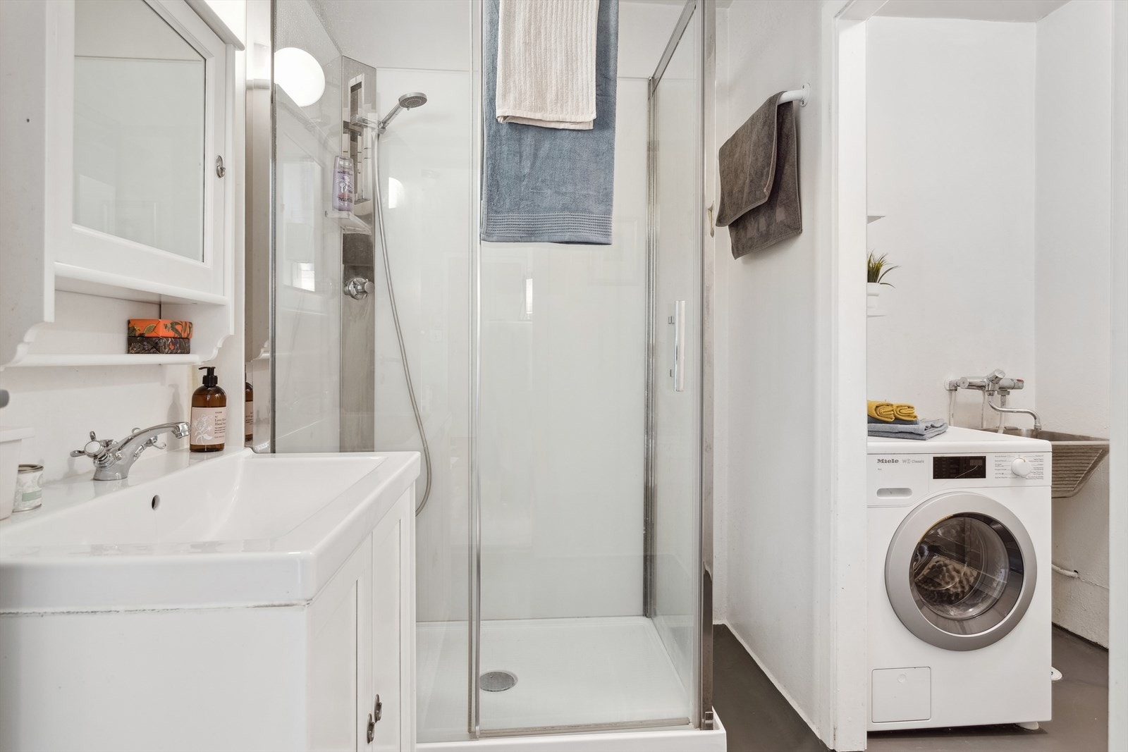 Badet er utstyrt med dusjkabinett, Innredning med servant, Opplegg for vaskemaskin (Kran og avløp). Galleribilde