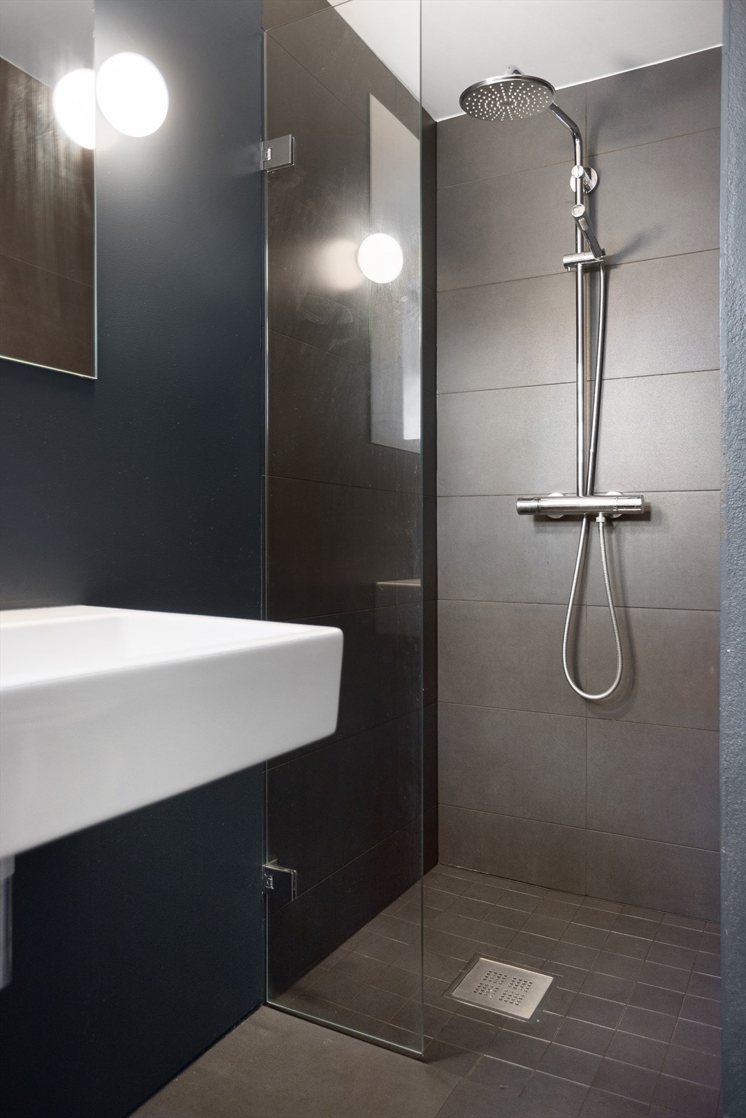 Badet består av vegghengt wc, servant og dusj i hjørne. Galleribilde