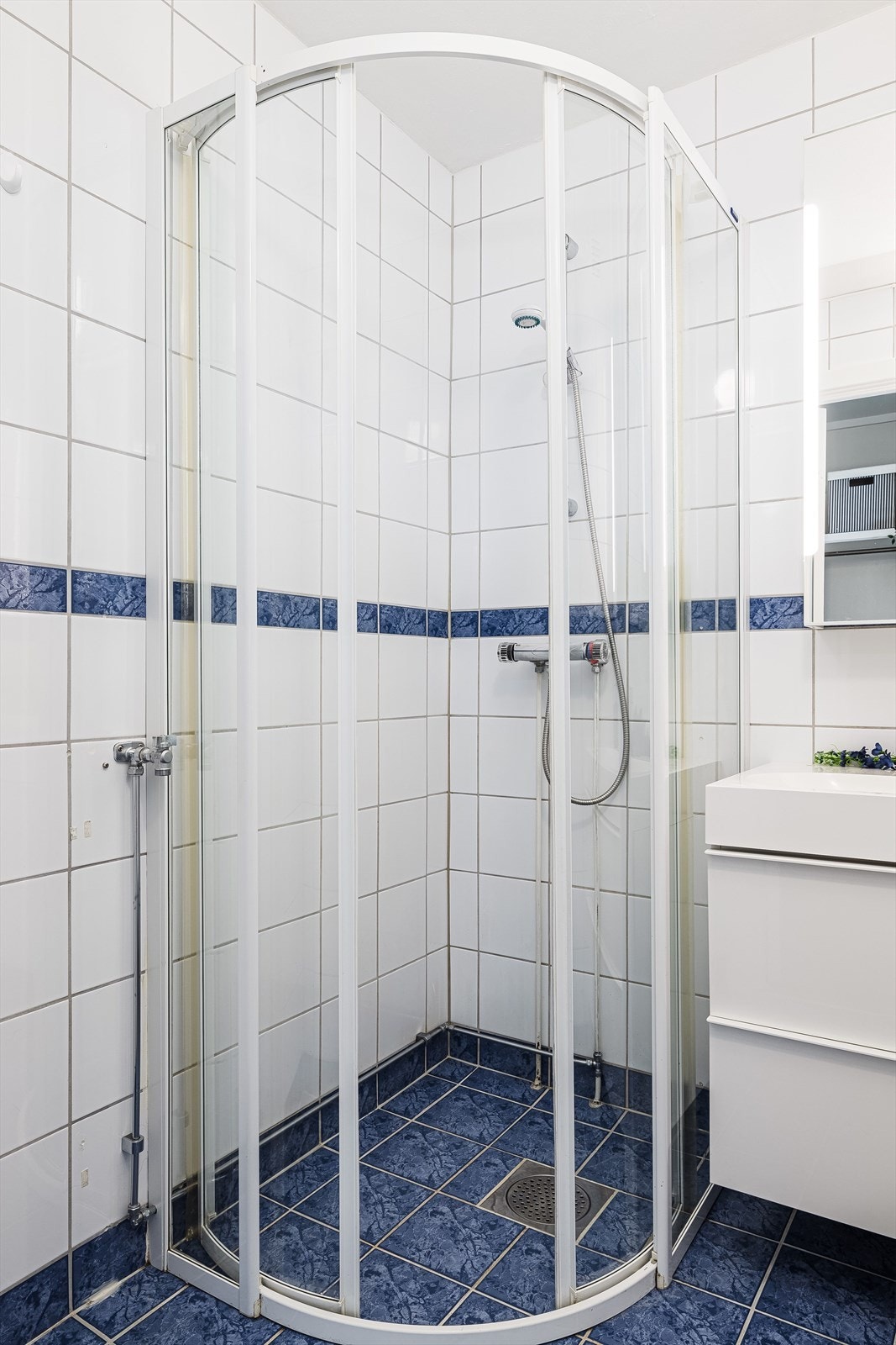 Badet er i dag utstyrt med gulvmontert toalett, dusjhjørne, baderomsinnredning med skuffer og heldekkende servant, samt opplegg for vaskemaskin. Galleribilde