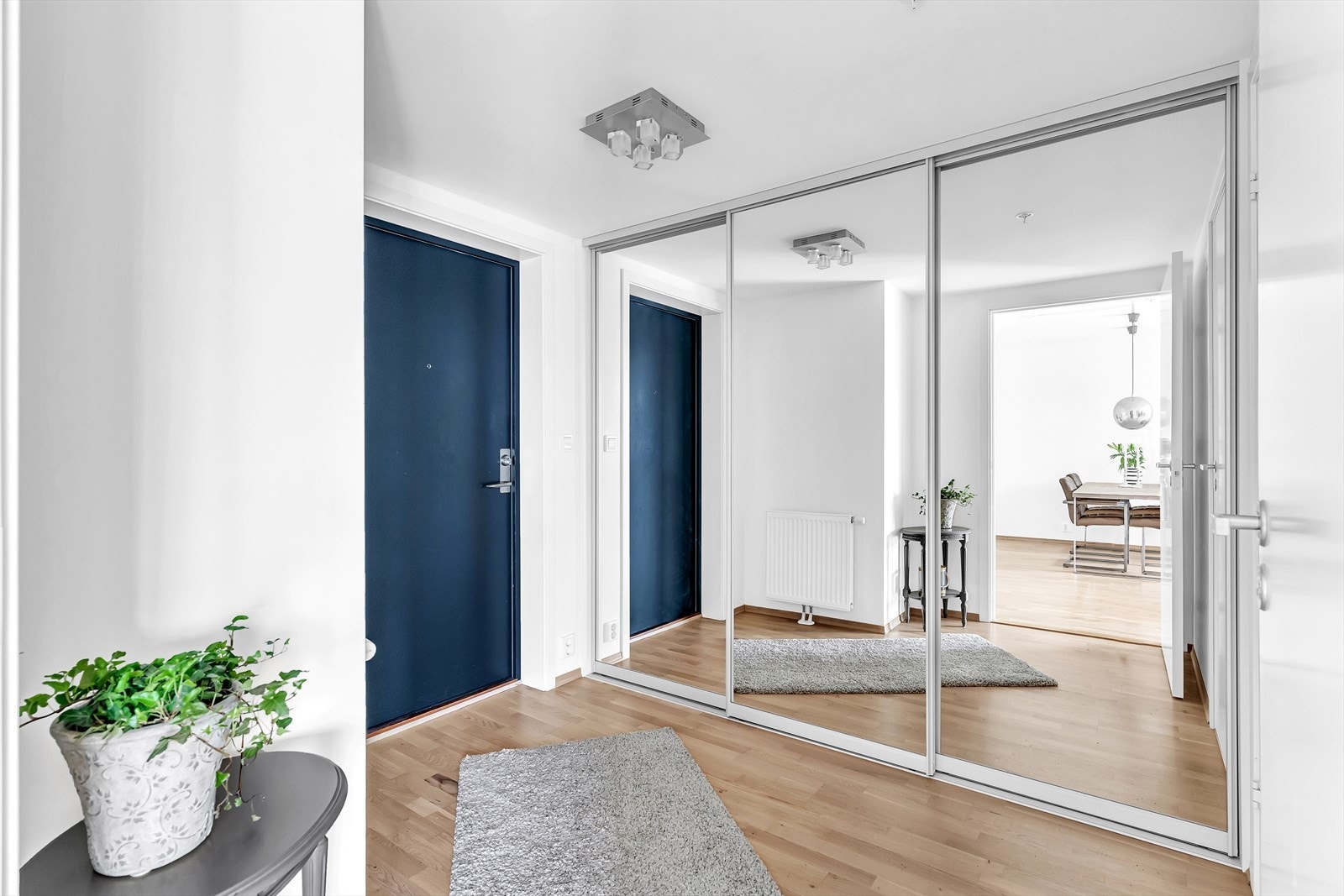 Innbydende og romslig entré med stor skyvedørsgarderobe med speilfronter. Galleribilde