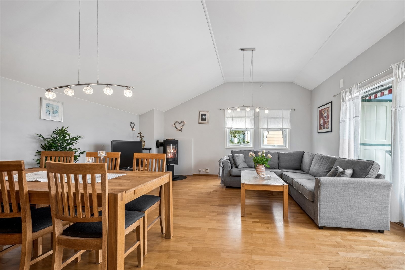 Stor og lys stue med store vinduer, perfekt for avslapning og sosiale sammenkomster. Peis som et hyggelig blikkfang i stuen. Galleribilde