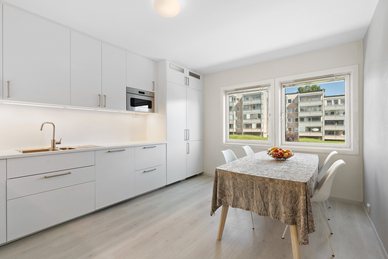 Smakfult og delikat kjøkken fra 2021 med stilren kjøkkeninnredning med slette sorte fronter og laminert benkeplate som innbyr til stor matglede Galleribilde